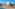 White INNSiDE hotel, sandy beach, straw umbrellas, and clear blue ocean.
