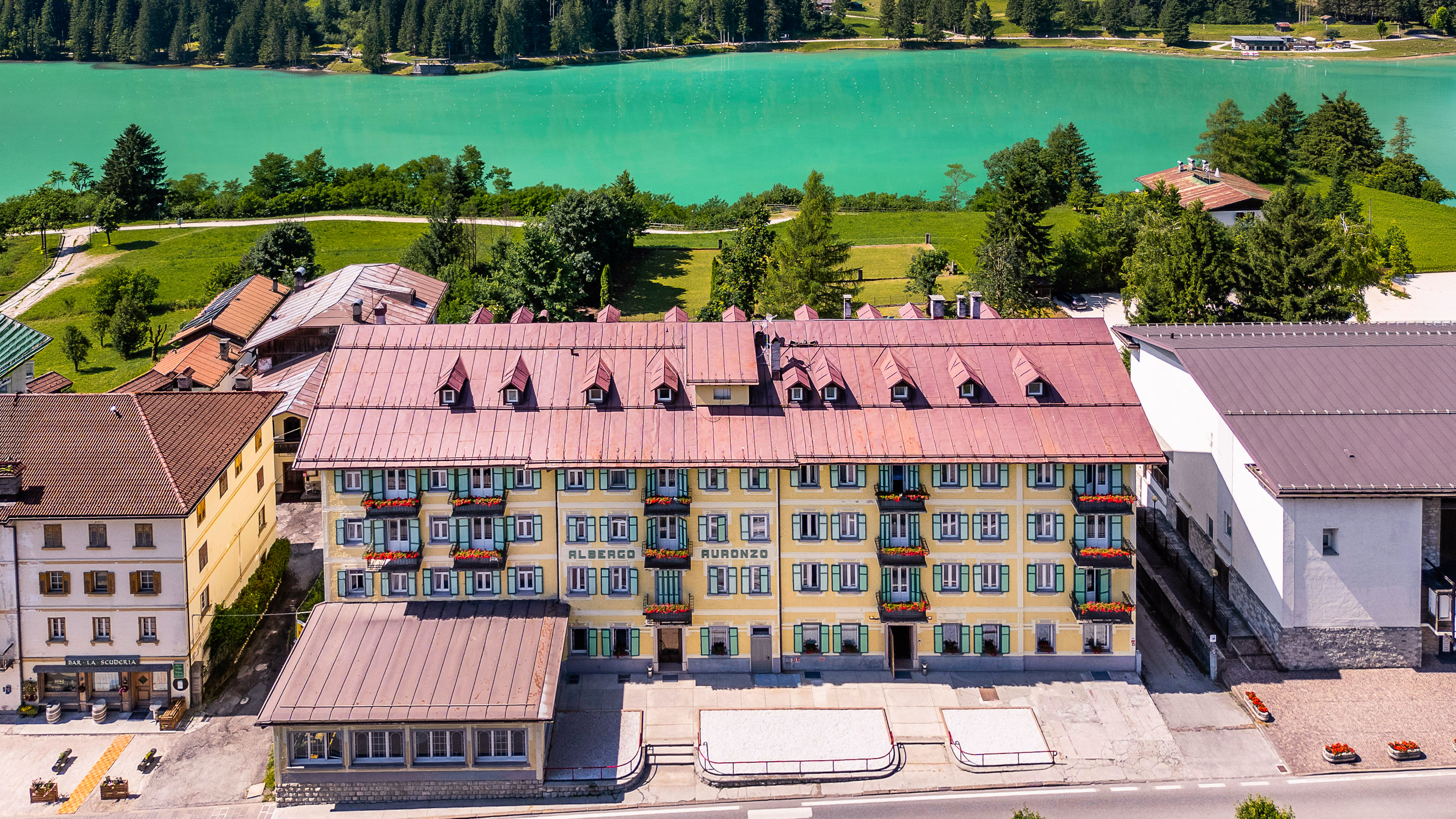 a building with a red roof and a lake