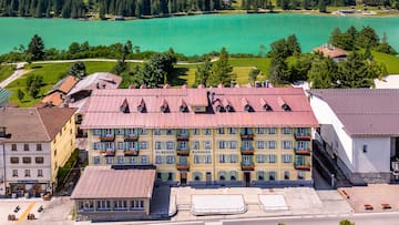 a building with a red roof and a lake