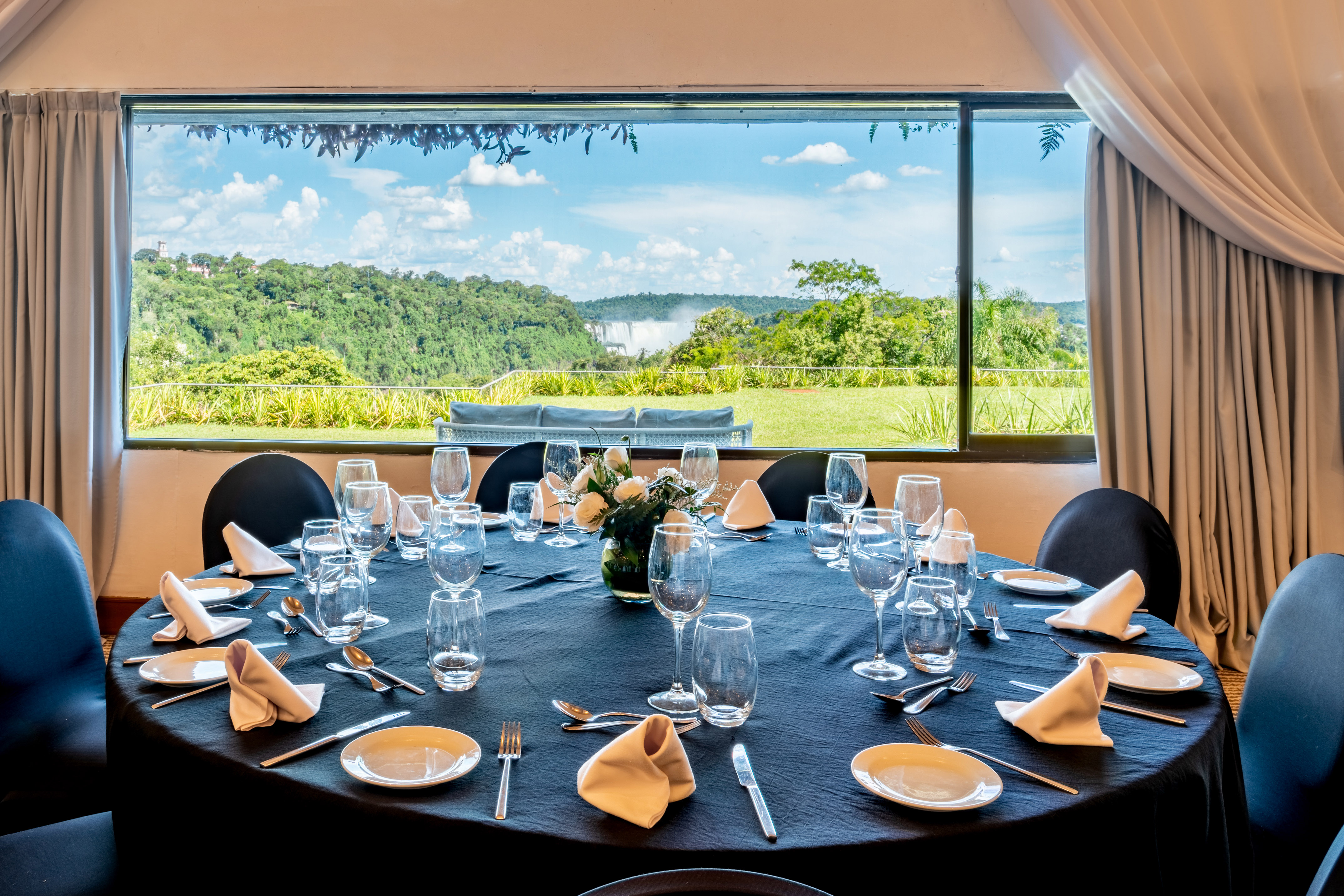 Set dining table with scenic view of distant Iguazu Falls.
