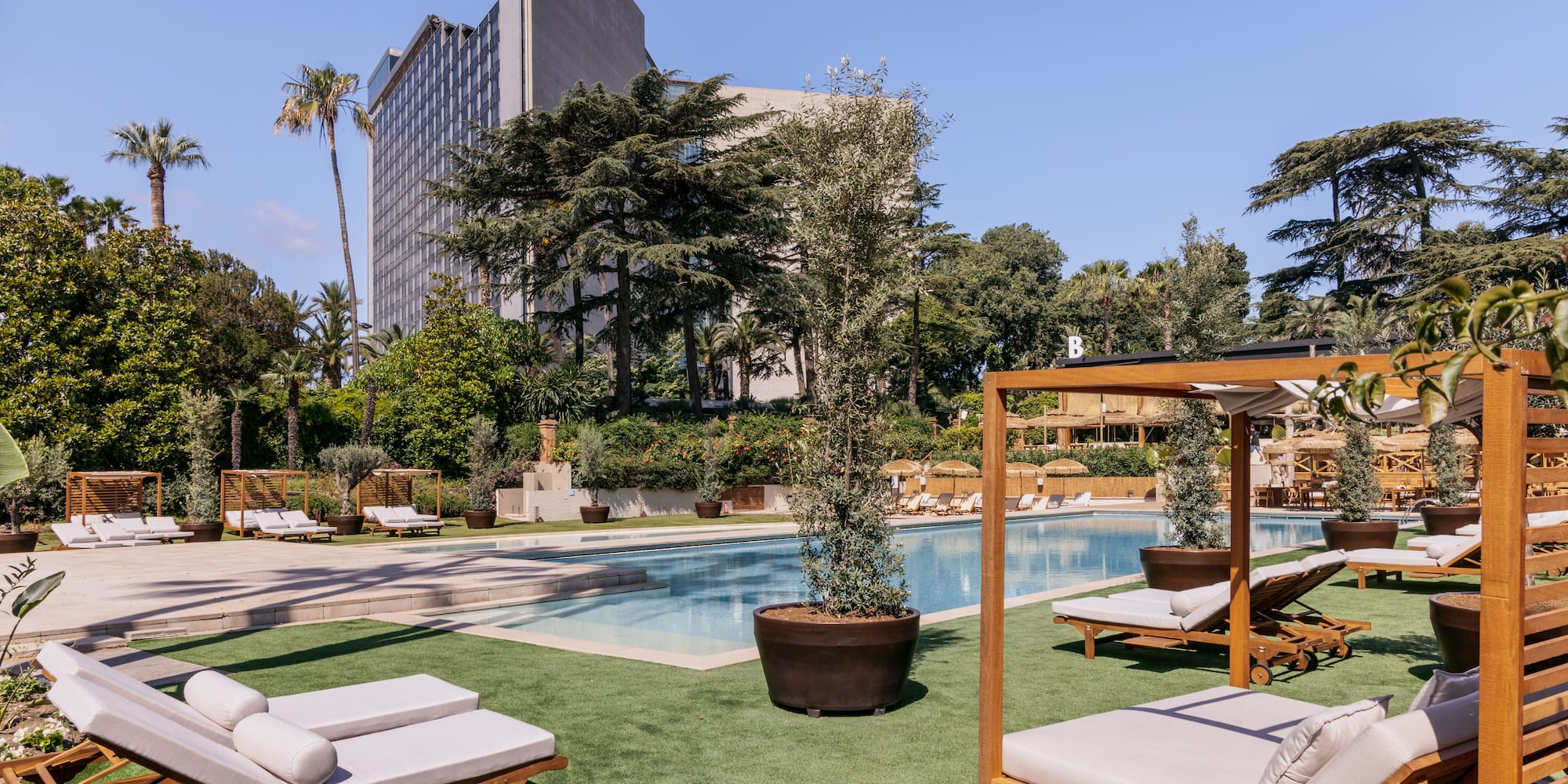 a pool with lounge chairs and trees in the background