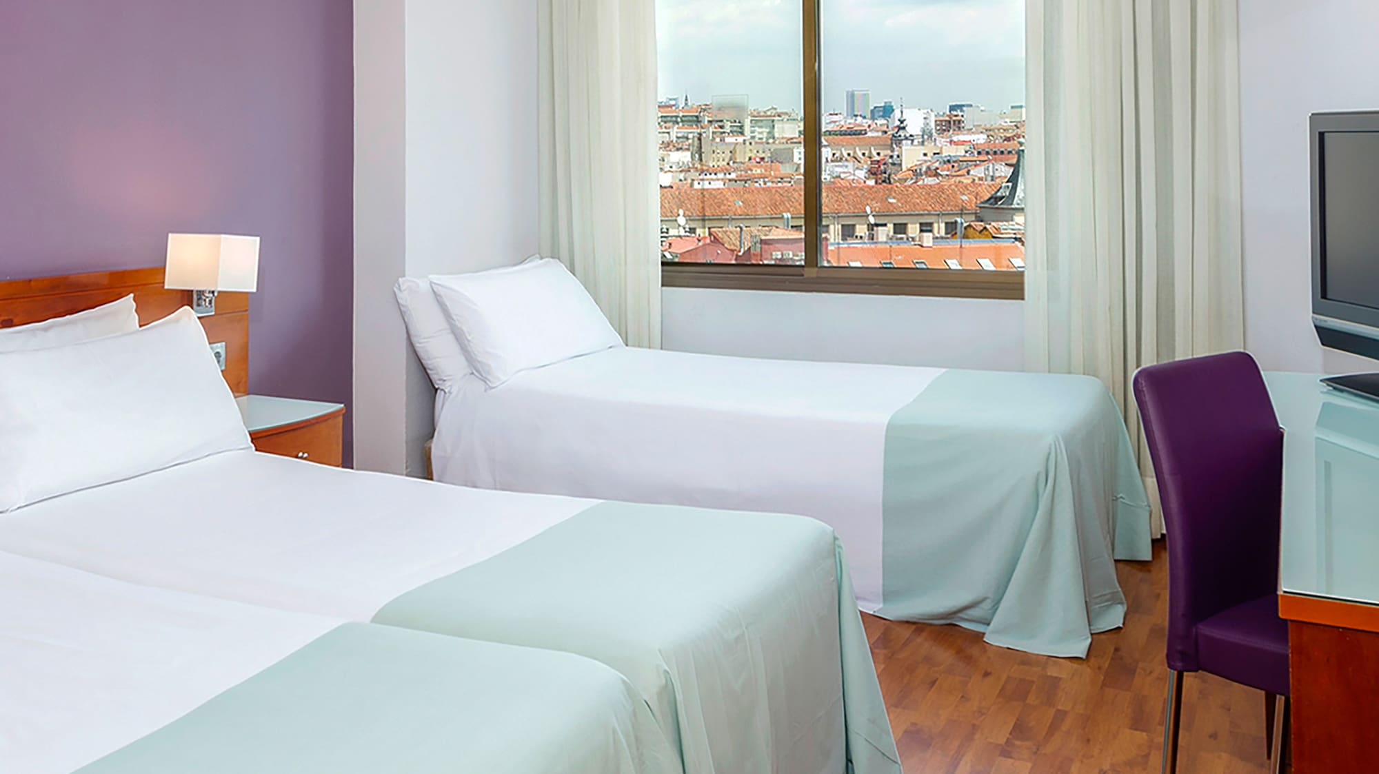 a room with two beds and a television