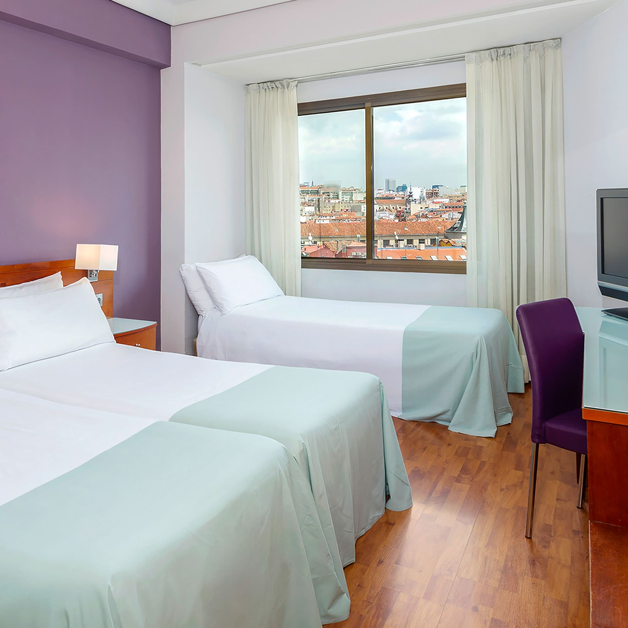 a room with two beds and a television