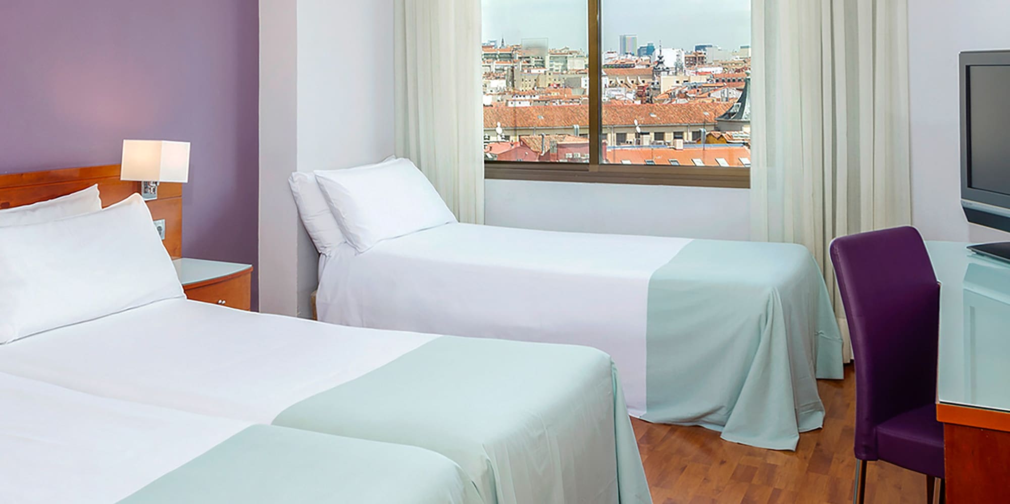 a room with two beds and a television