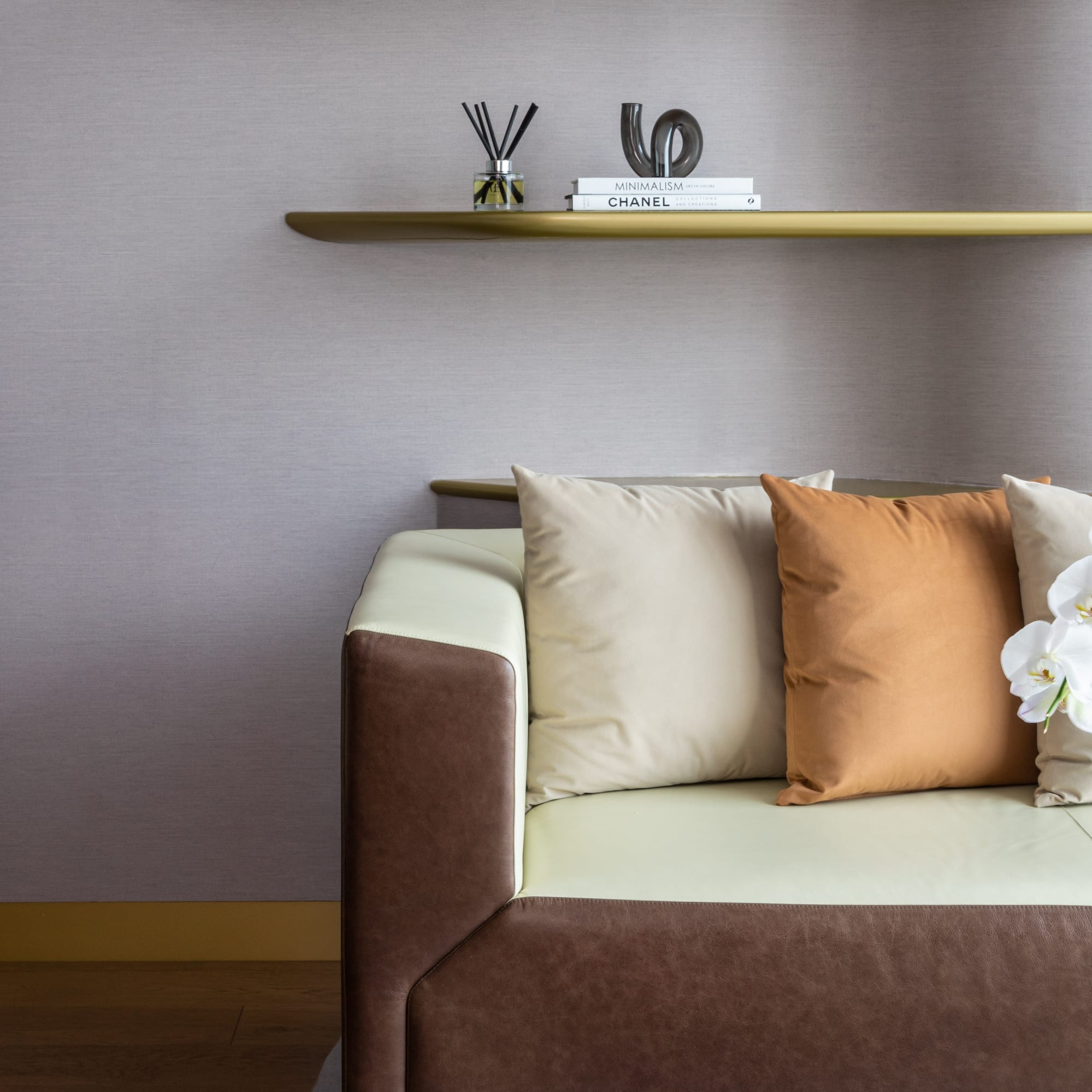 a couch with pillows and a shelf with books