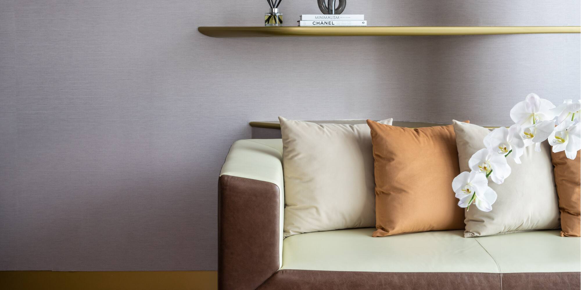 a couch with pillows and a shelf with books