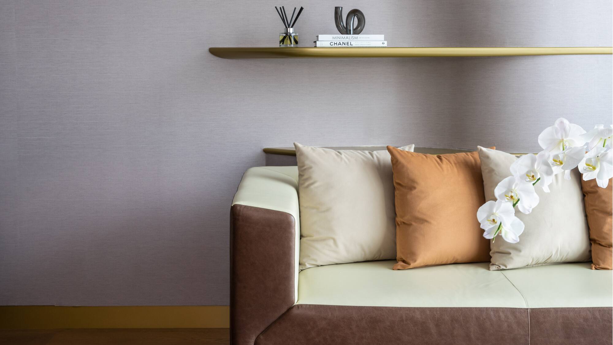 a couch with pillows and a shelf with books