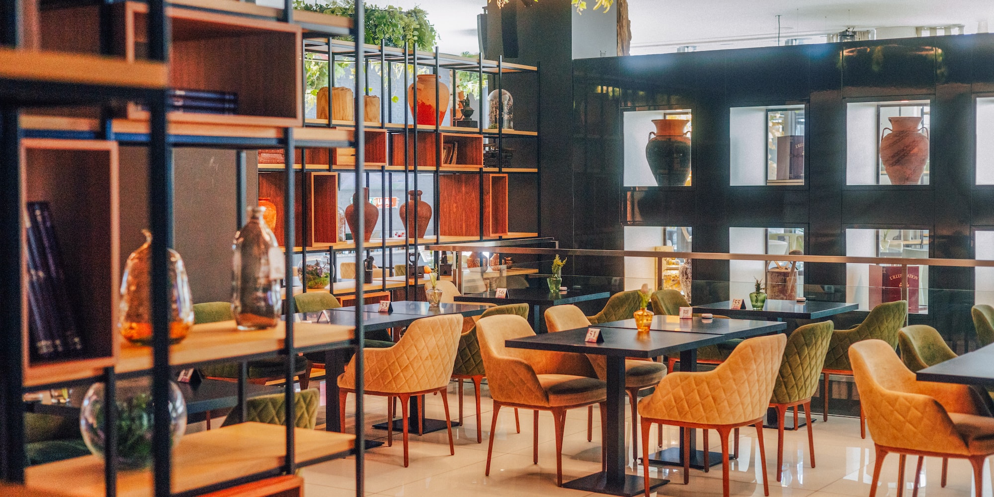 Modern restaurant interior with stylish chairs, tables, and decorated shelves.