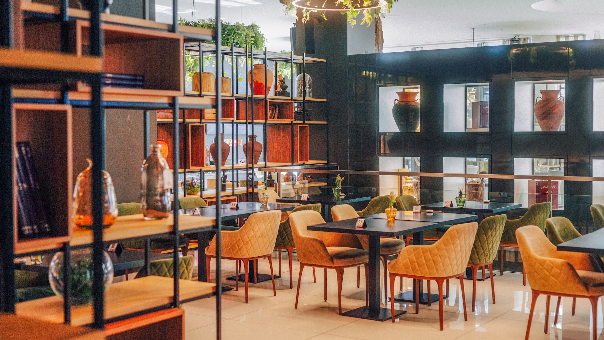 Modern restaurant interior with stylish chairs, tables, and decorated shelves.