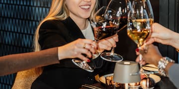 a group of people clinking wine glasses at a table