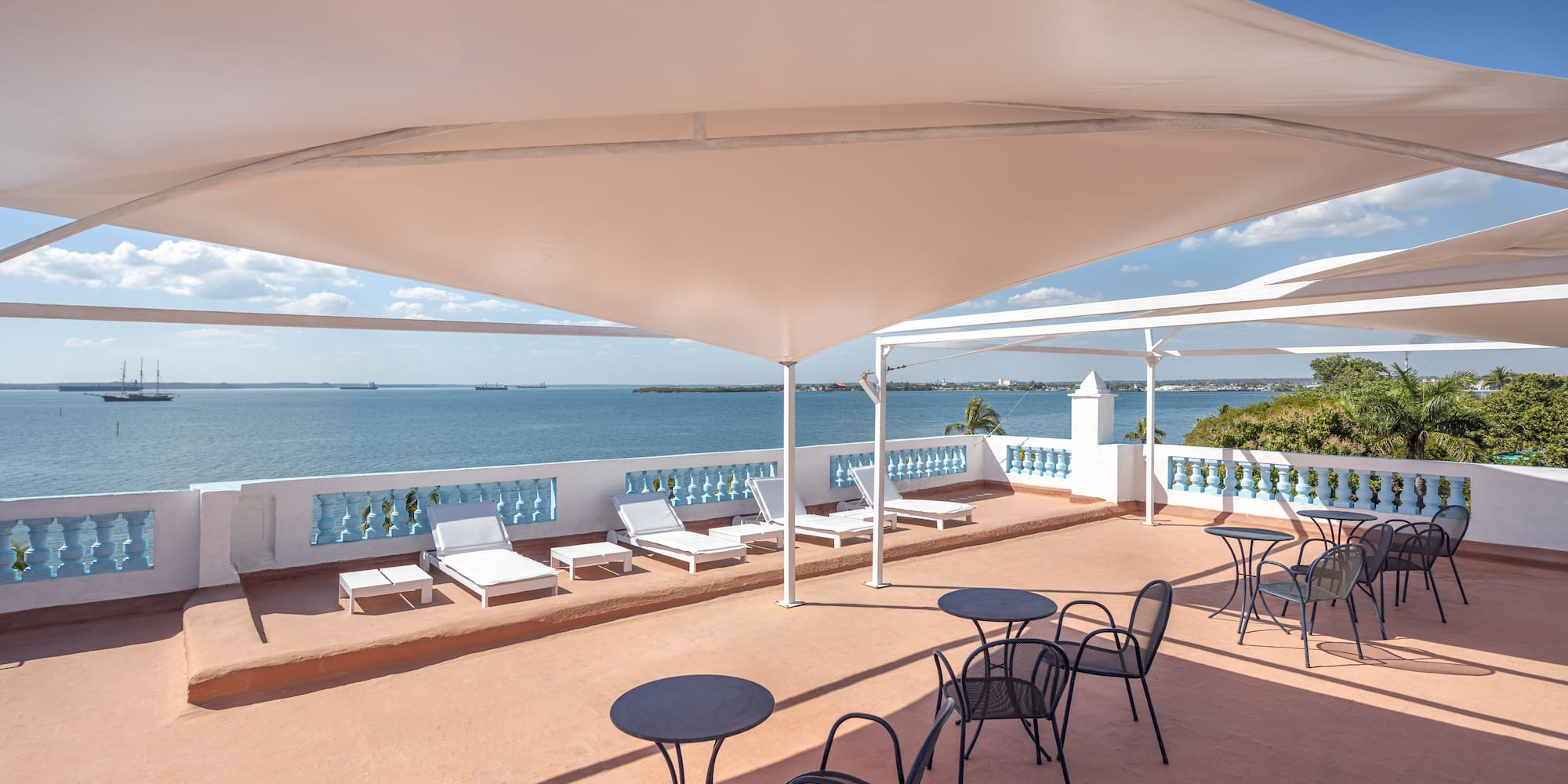 a patio with chairs and a large body of water