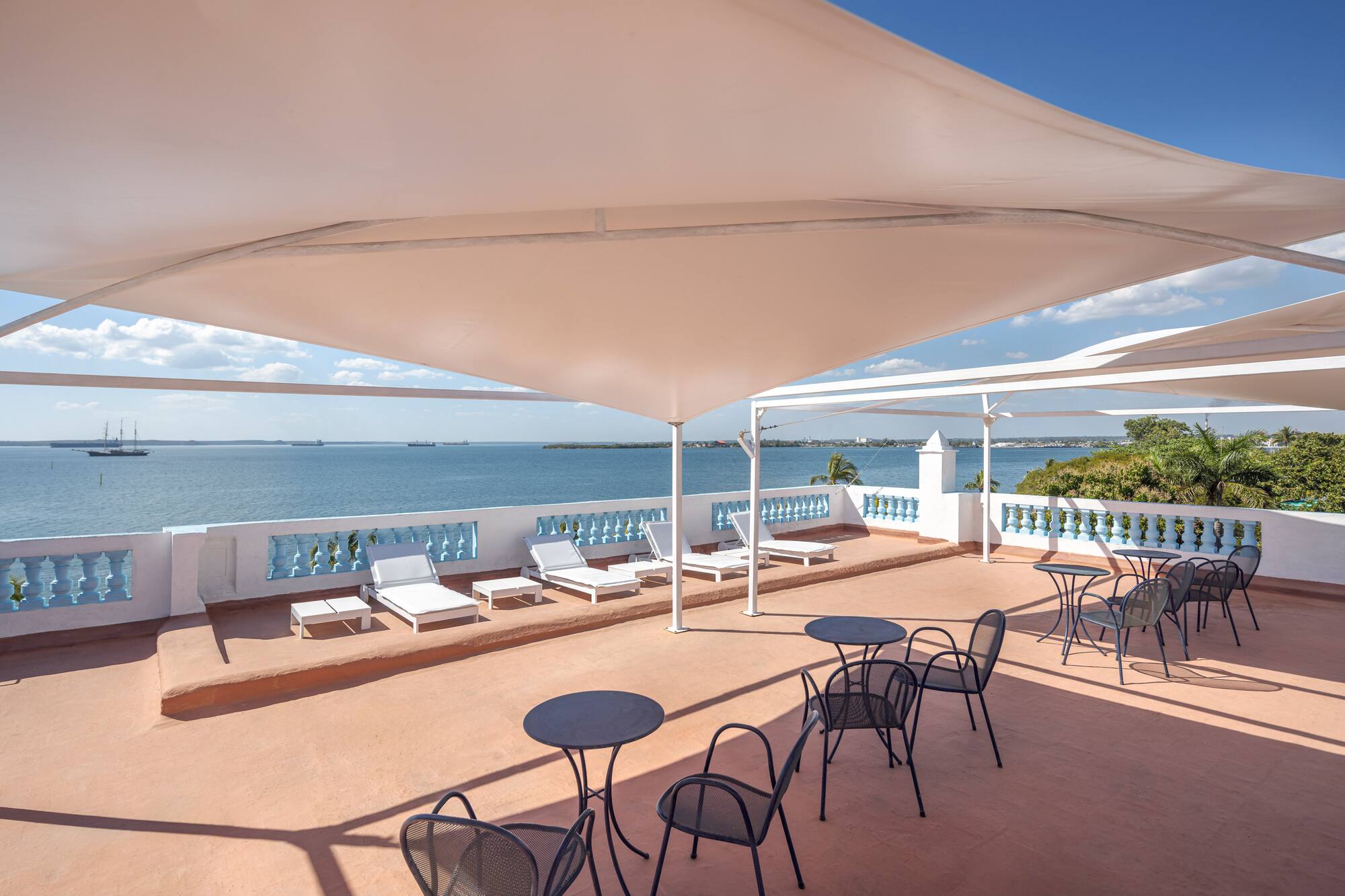 a patio with chairs and a large body of water