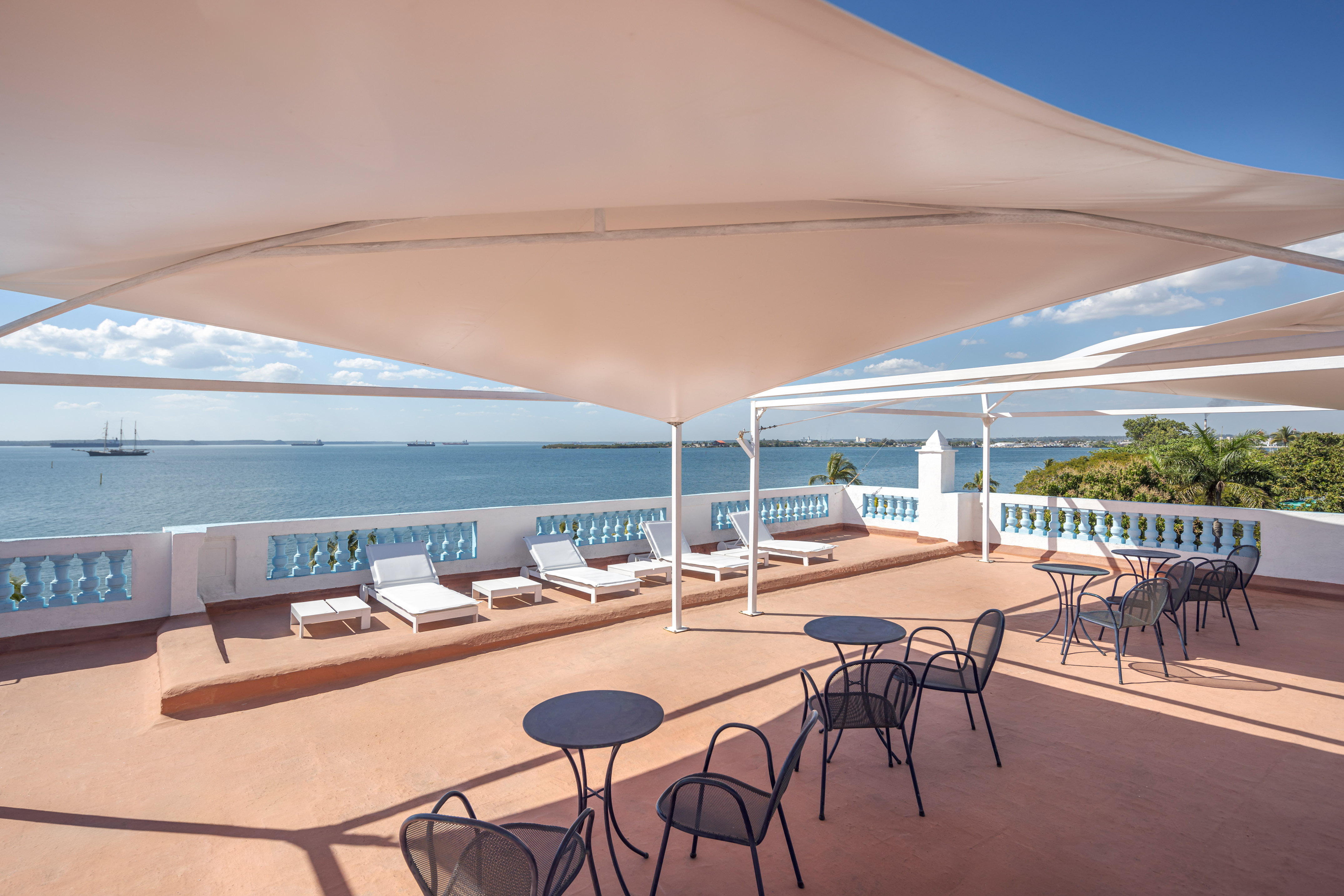 a patio with chairs and a large body of water