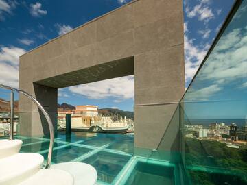 a glass pool with a bridge over water.