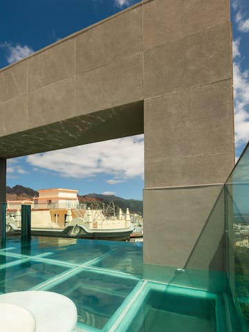 a glass pool with a bridge over water.