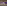 Modern convention hall with curved walls, stage, seating, purple lighting.