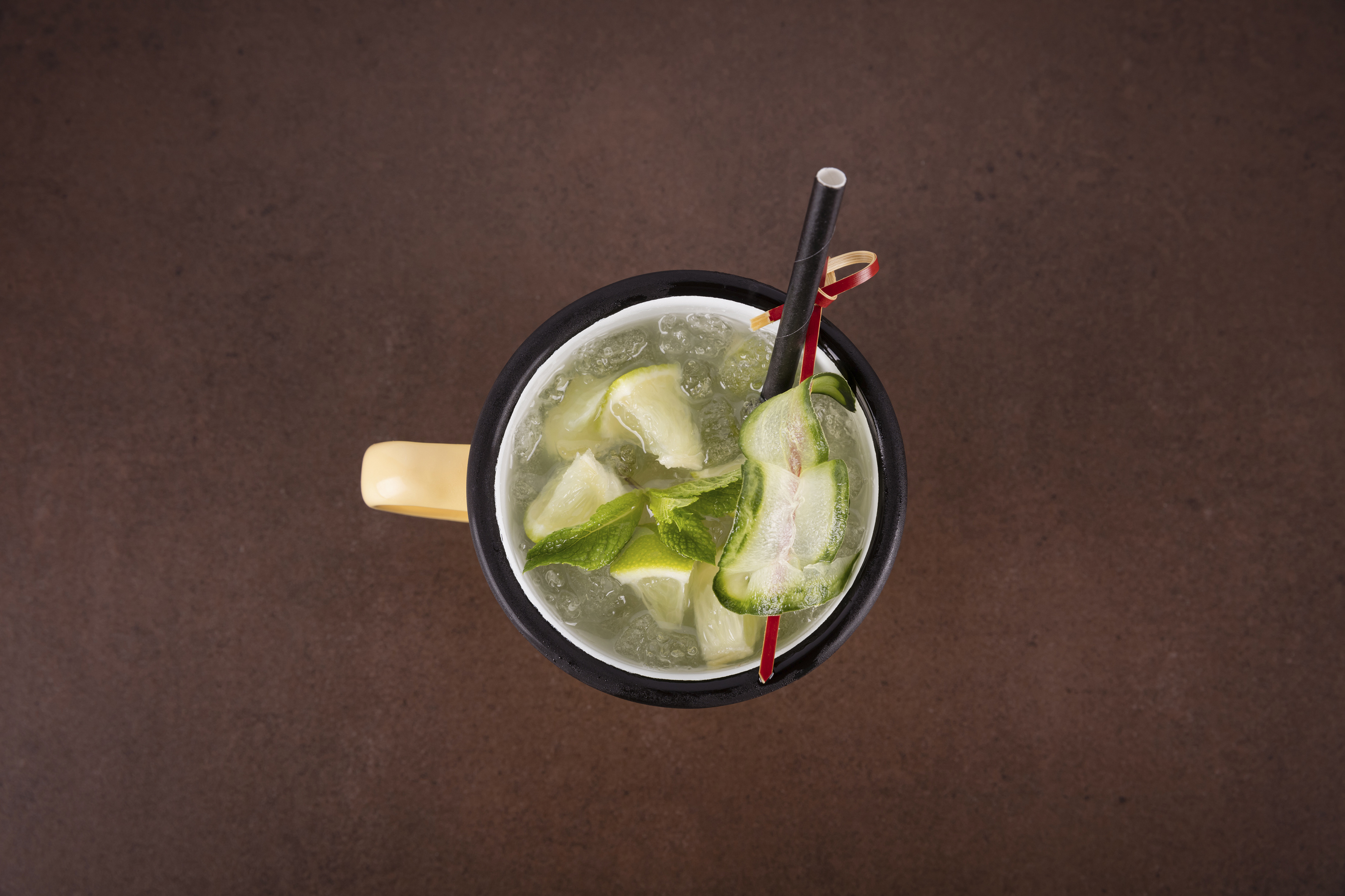 Refreshing lime and mint cocktail with crushed ice and cucumber garnish.