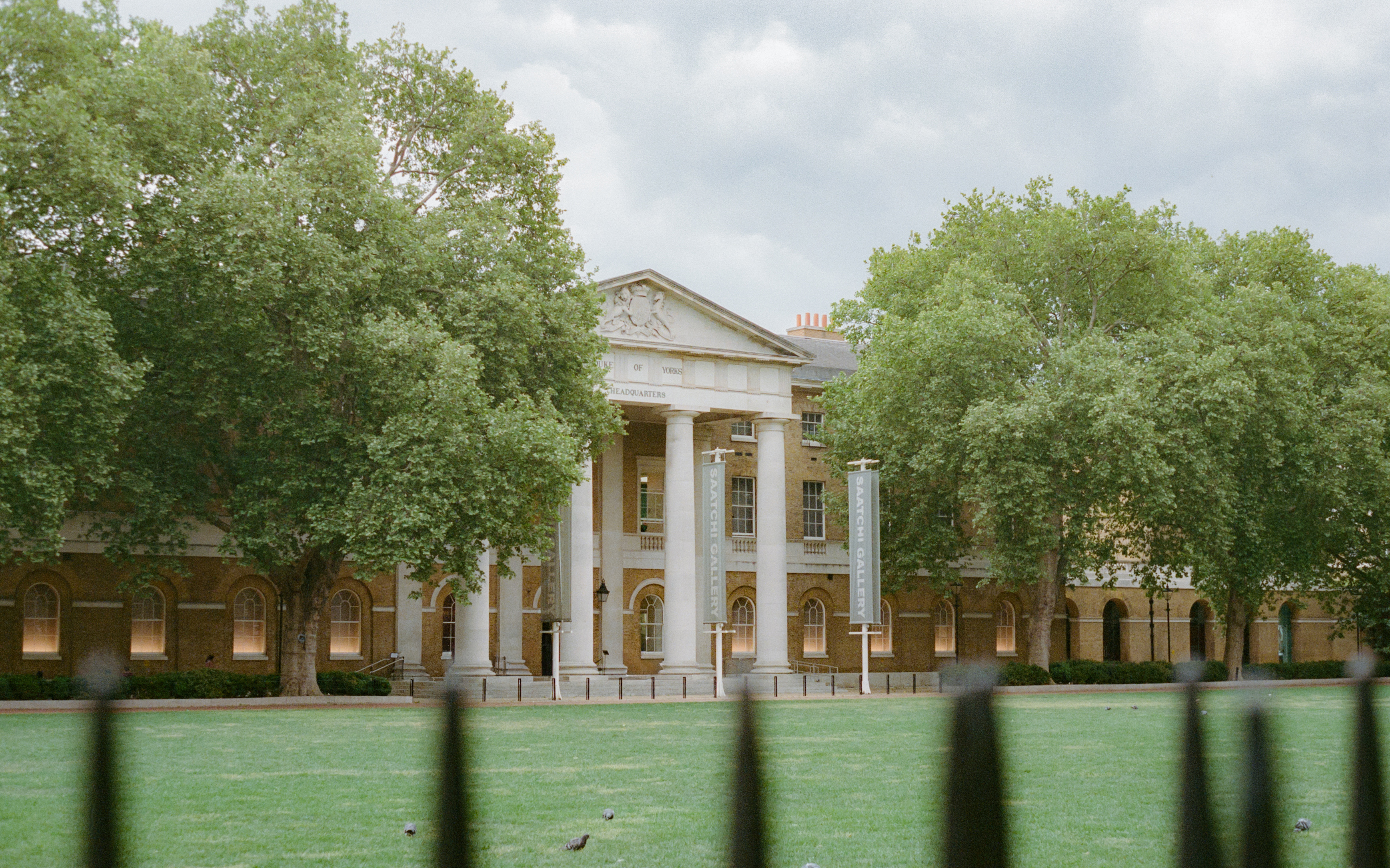 Saatchi Gallery, Londres: fachada neoclásica, columnas, árboles y césped verde.
