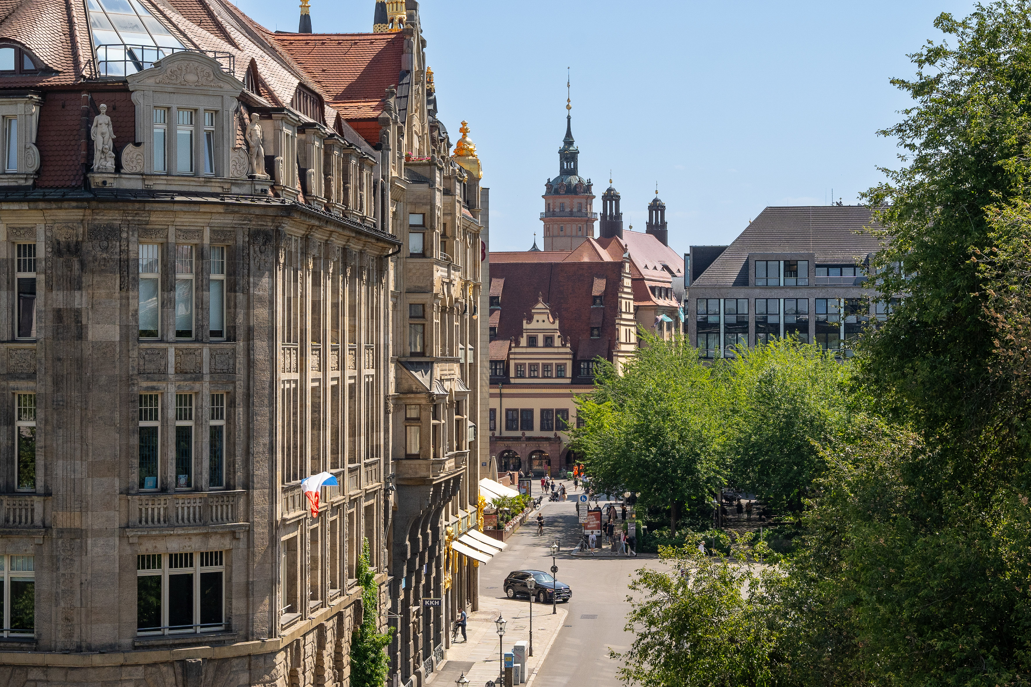 Leipzig city street with historic buildings and Old Rathaus tower.