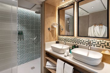 a bathroom with two sinks and a shower