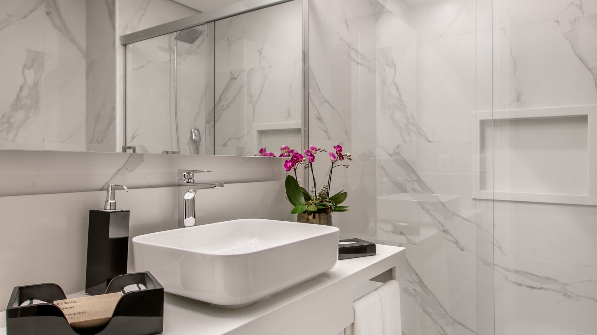 a bathroom with a glass shower and sink