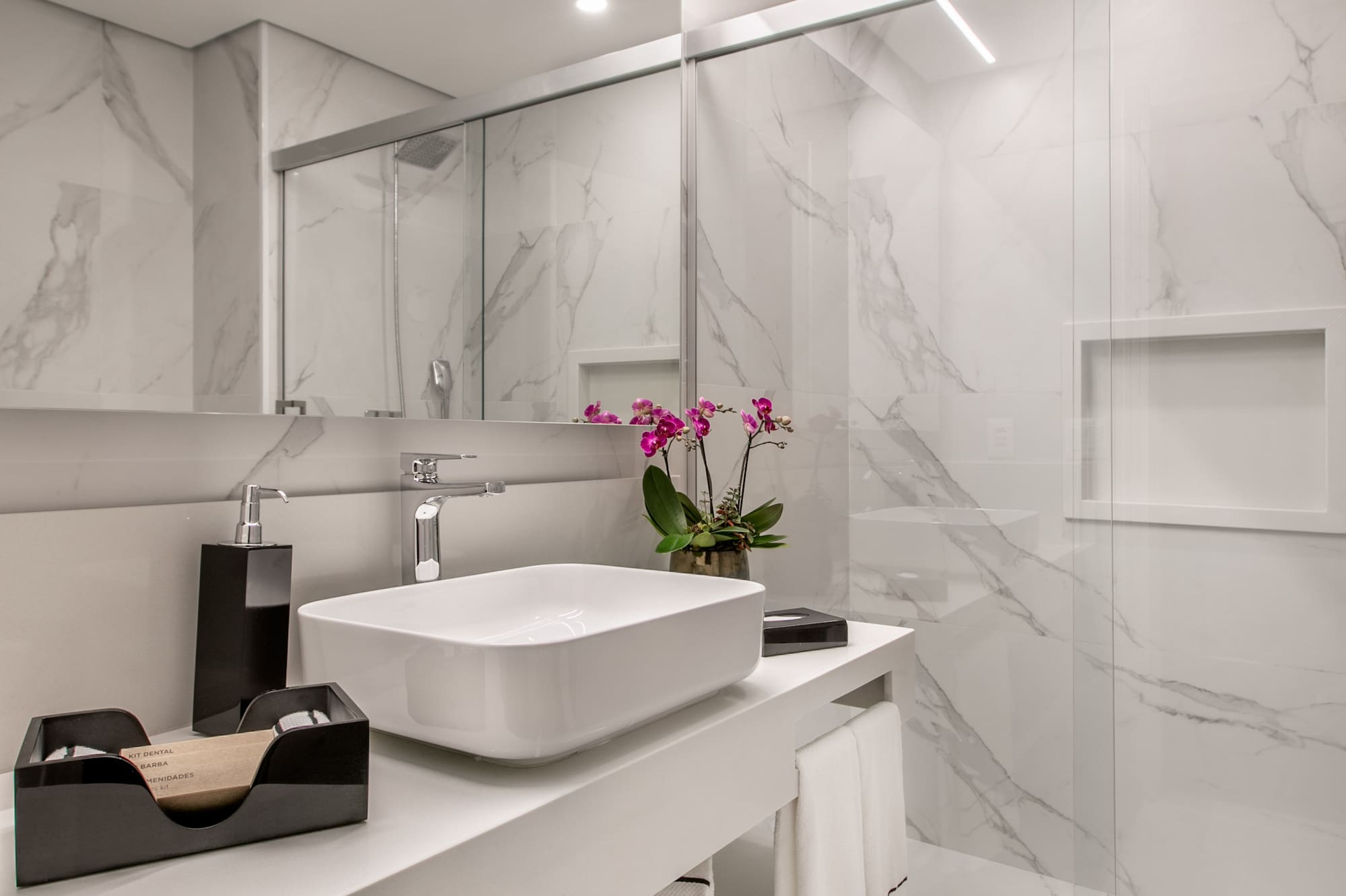 a bathroom with a glass shower and sink