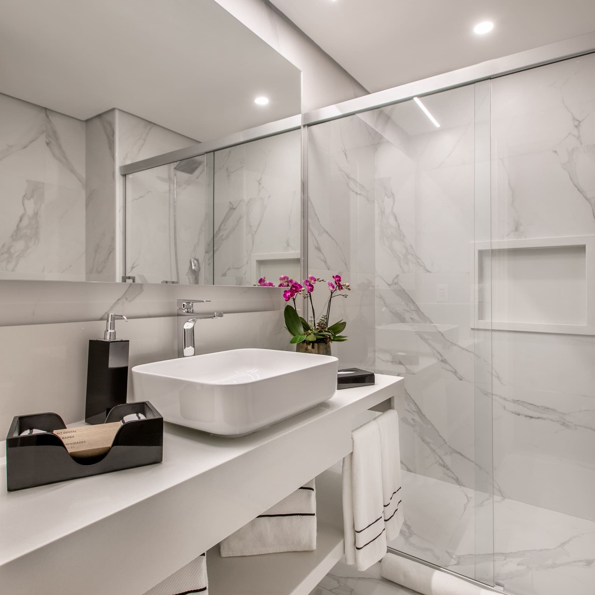 a bathroom with a glass shower and sink