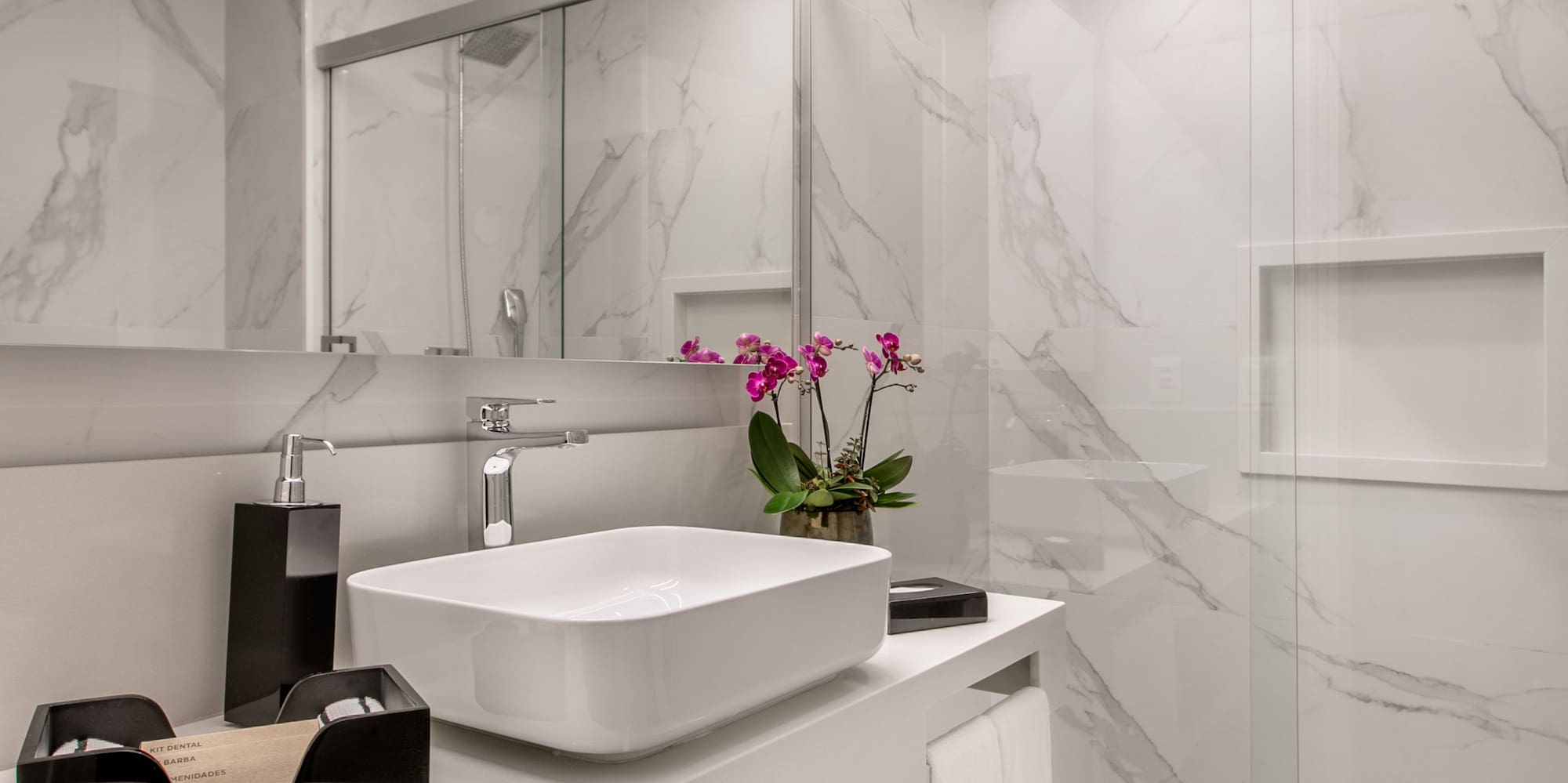 a bathroom with a glass shower and sink