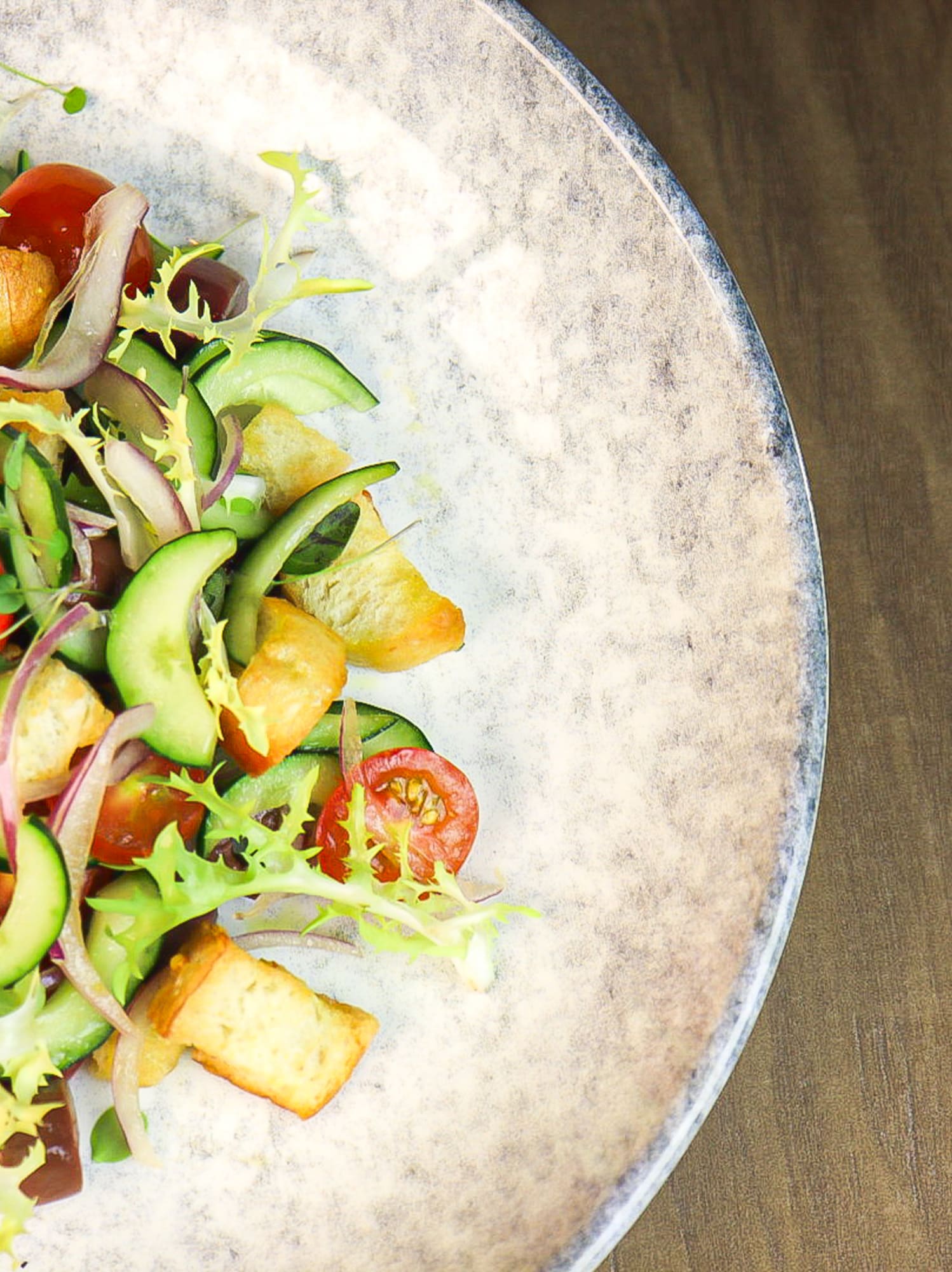 a plate of salad on a wood table