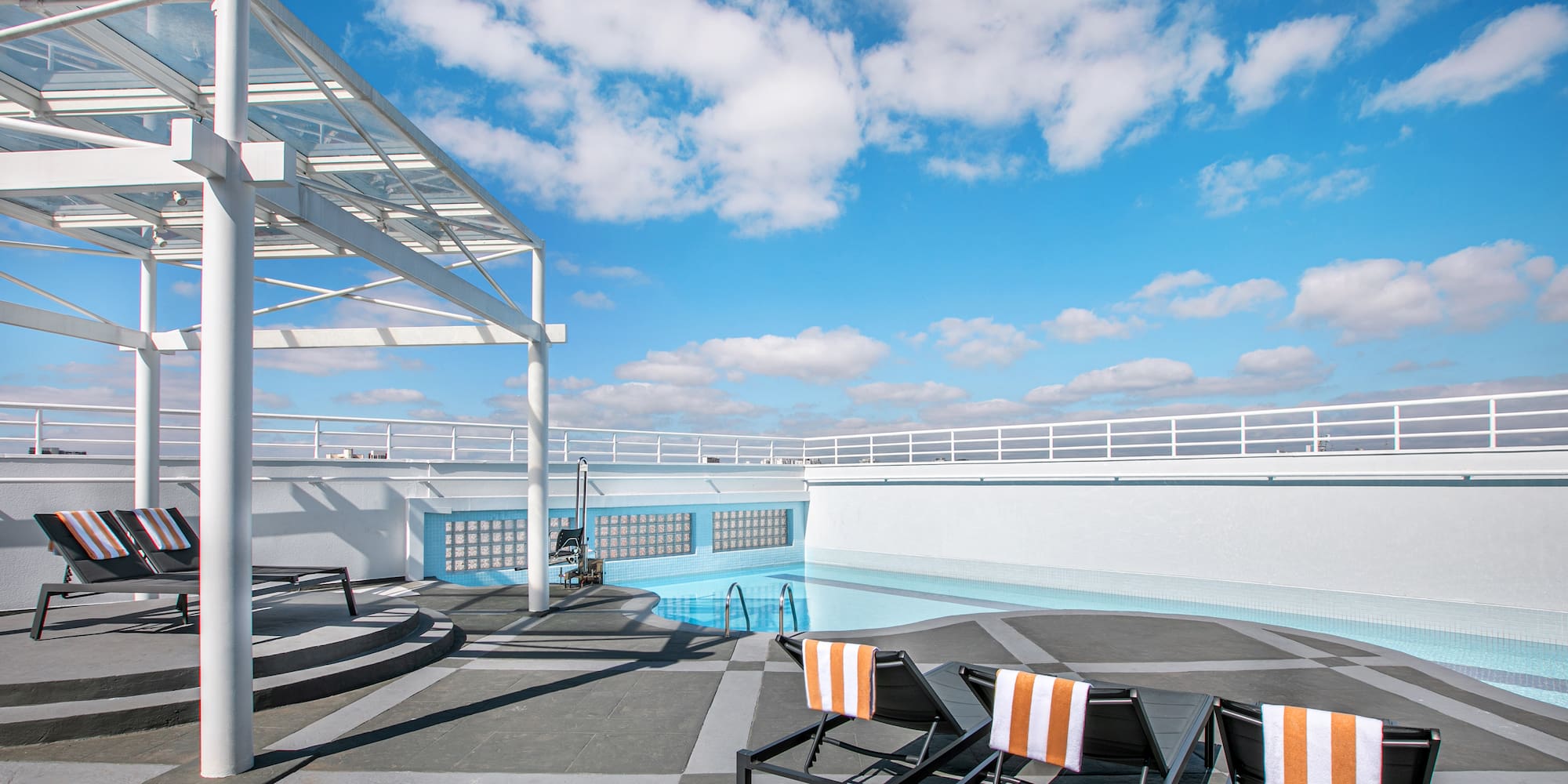 a pool with chairs on a roof