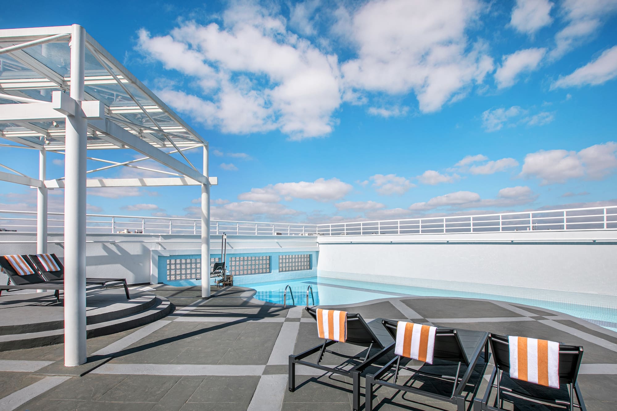 a pool with chairs on a roof
