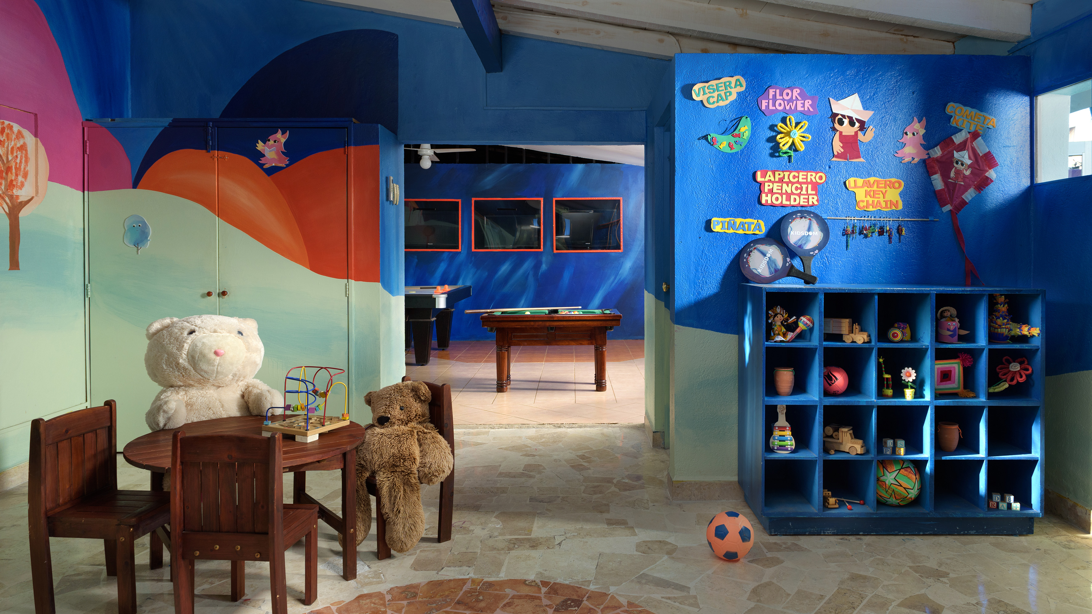 Vibrant children's play area with teddy bears, toys, colorful walls, and game room.