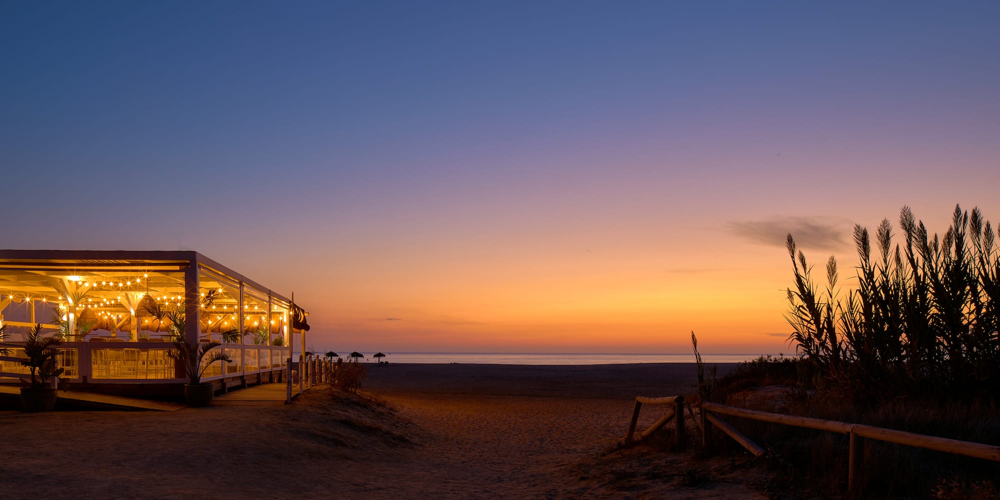 a building with lights on the beach