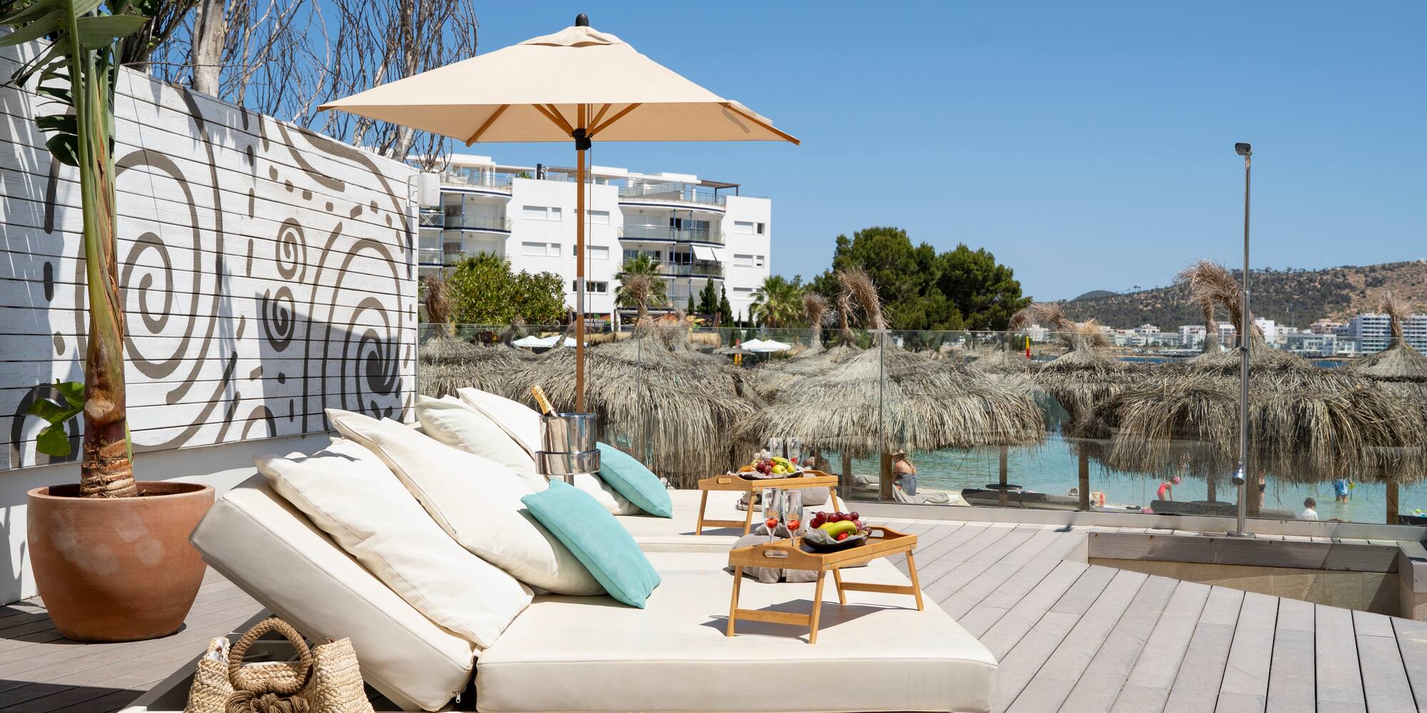 a lounge chair with umbrellas and a table on a deck