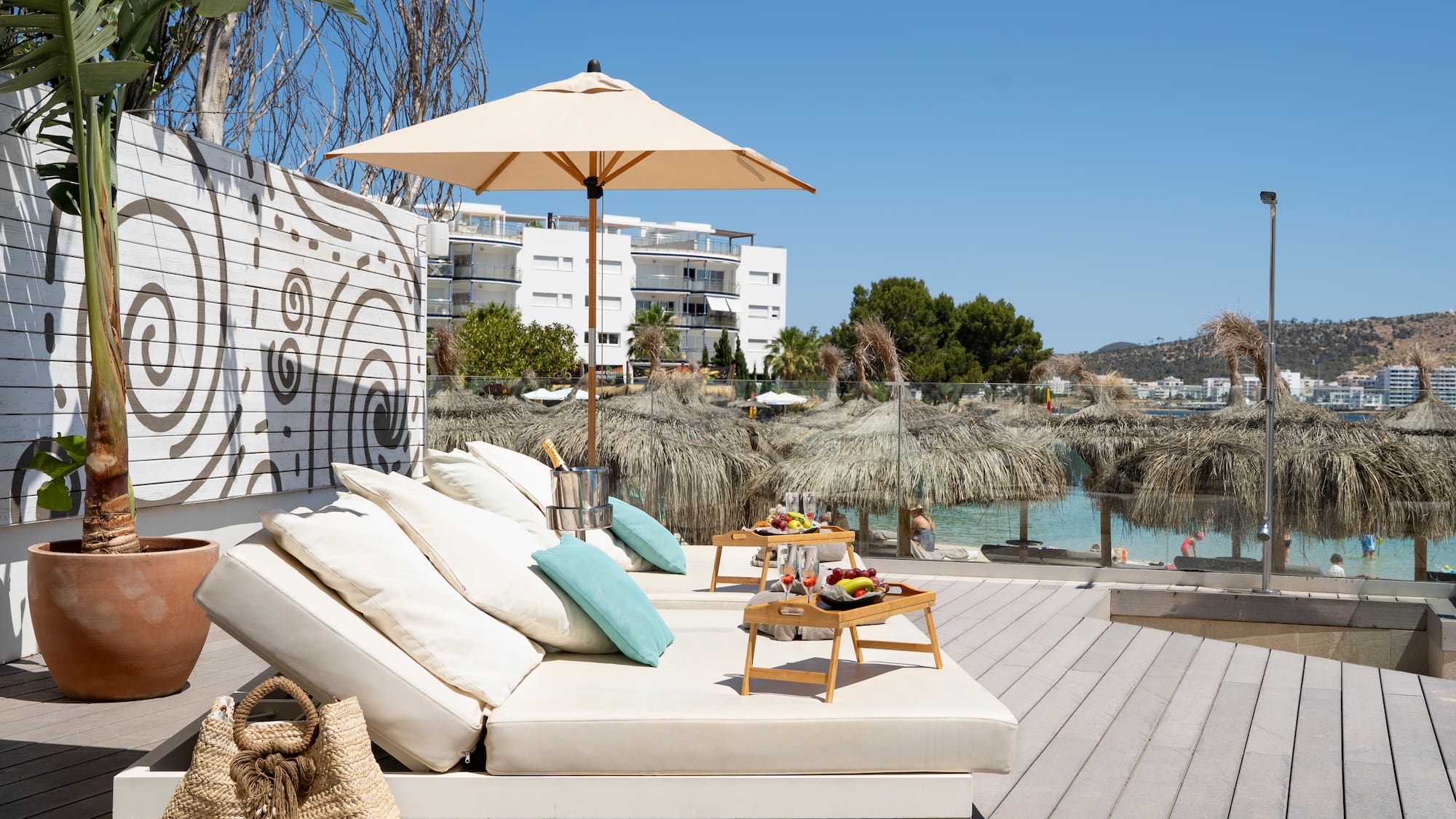 a lounge chair with umbrellas and a table on a deck