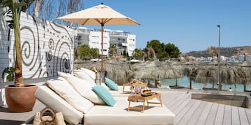 a lounge chair with umbrellas and a table on a deck
