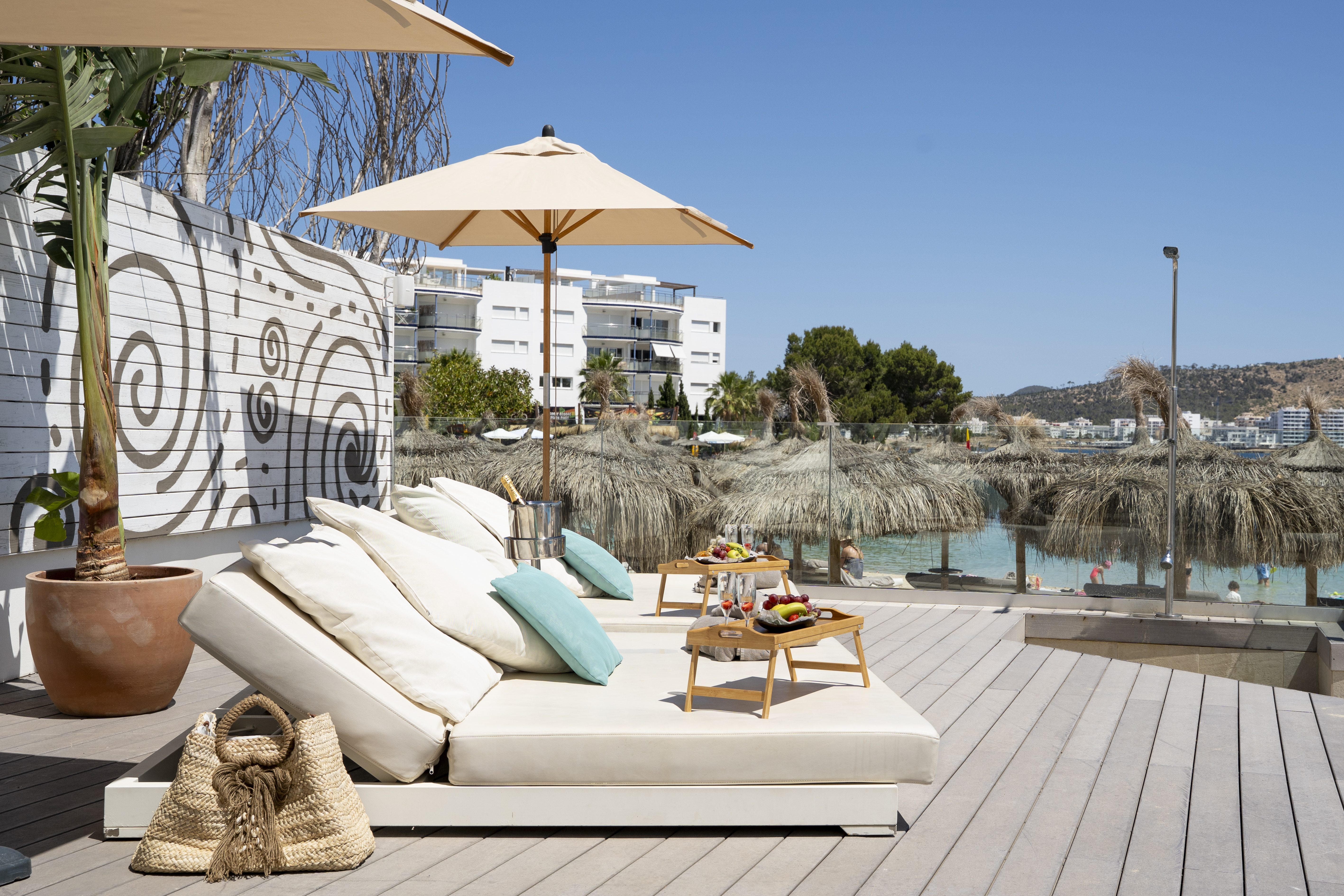 a lounge chair with umbrellas and a table on a deck