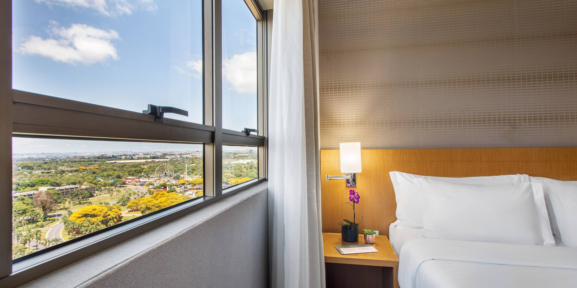 a bedroom with a window and a view of a valley