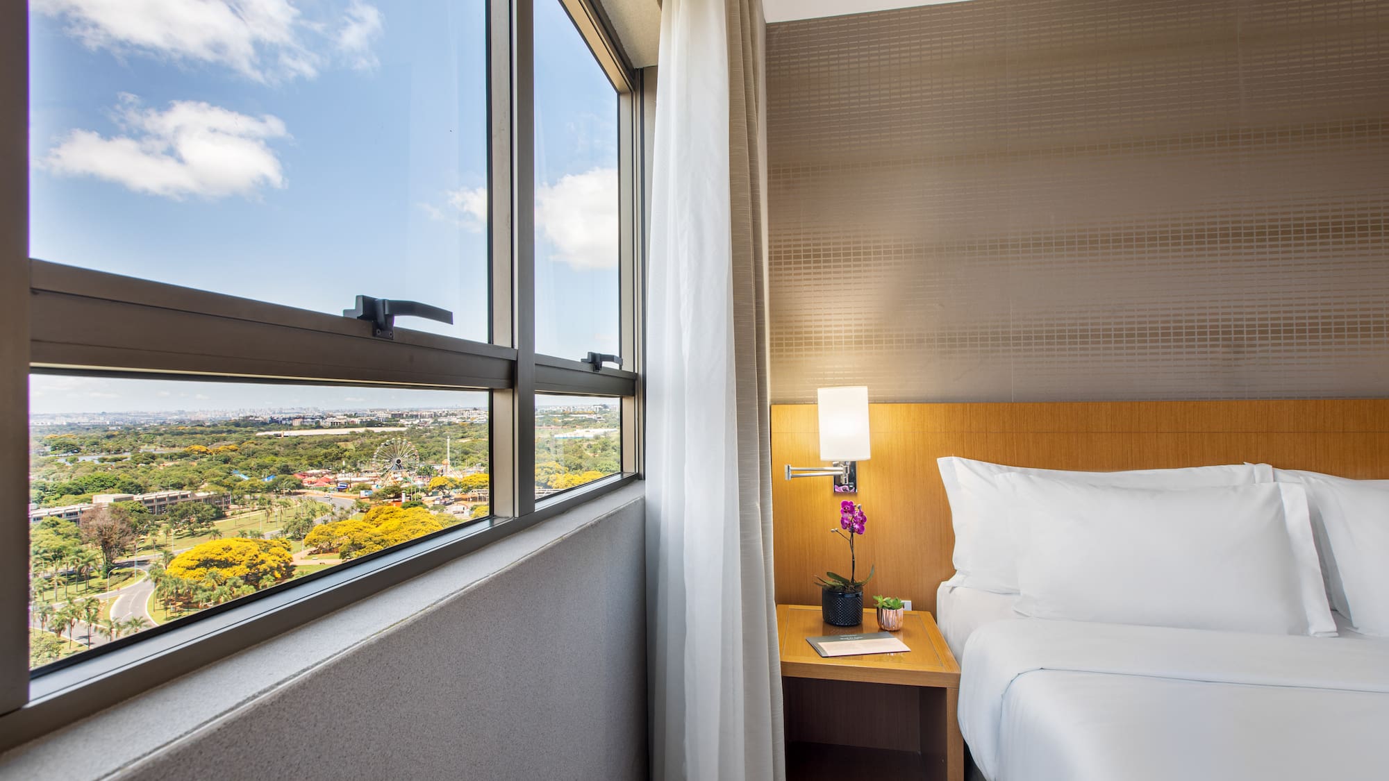 a bedroom with a window and a view of a valley