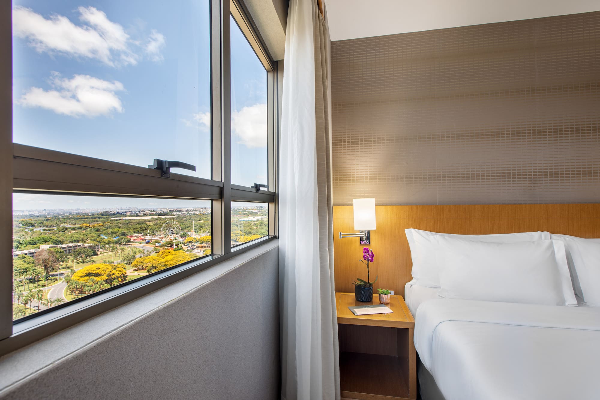 a bedroom with a window and a view of a valley