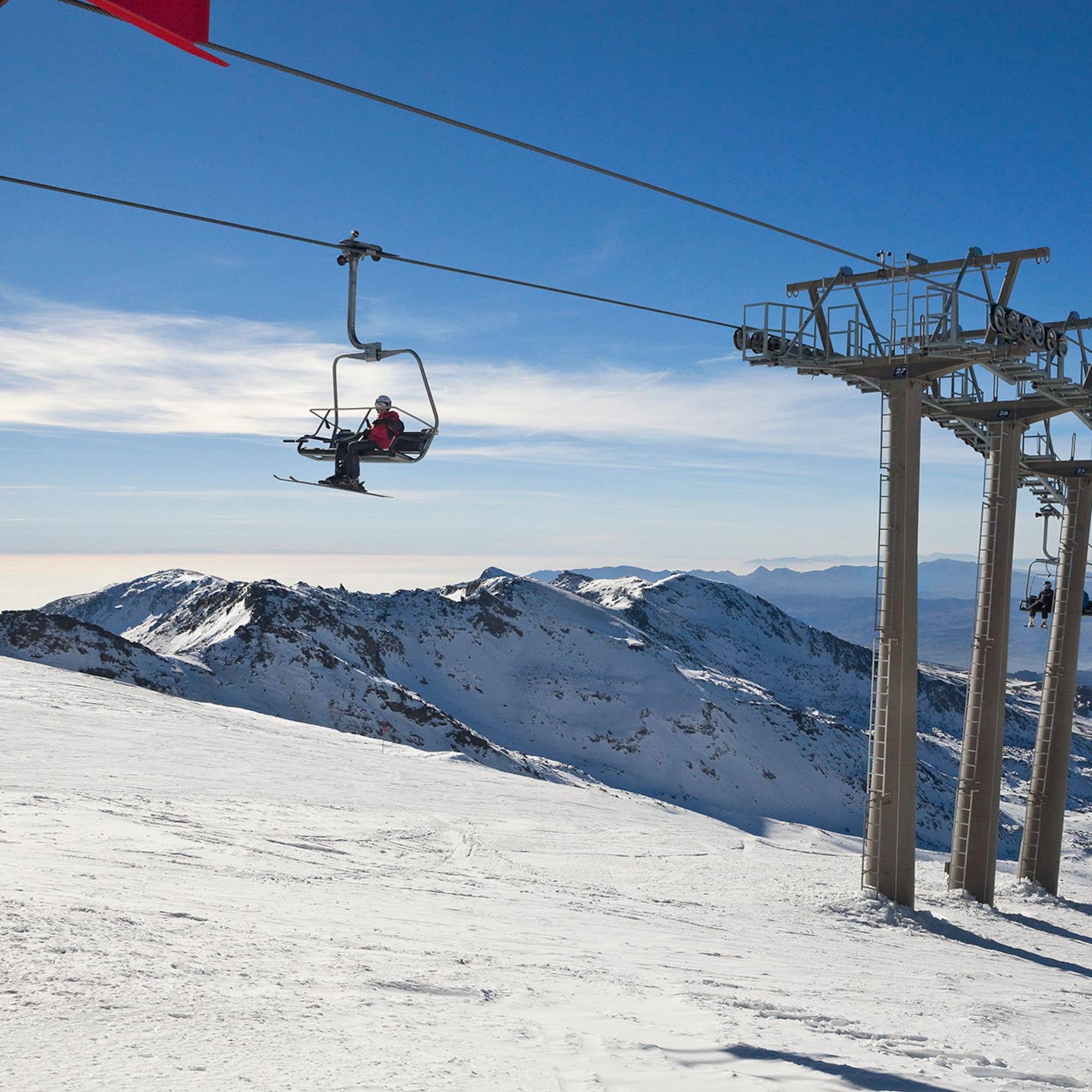 a person on a ski lift above a snowy mountain