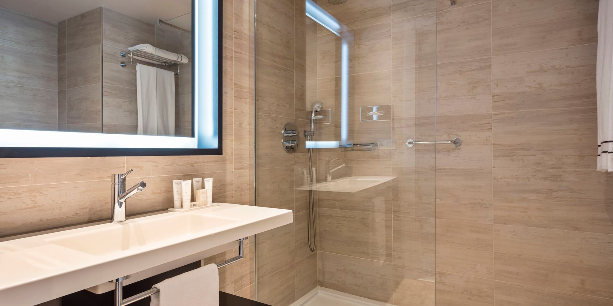 a bathroom with a glass shower and a sink