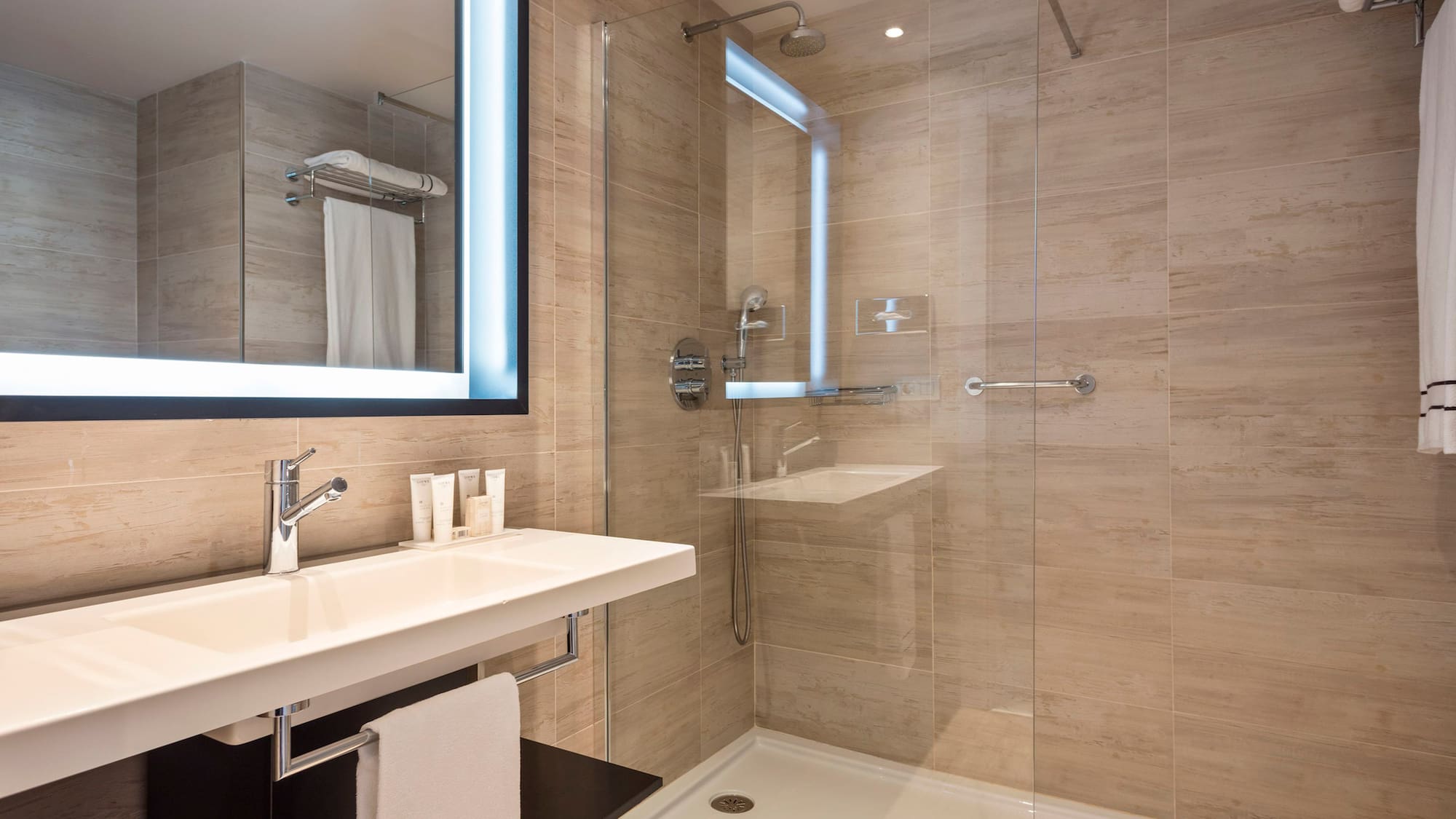 a bathroom with a glass shower and a sink