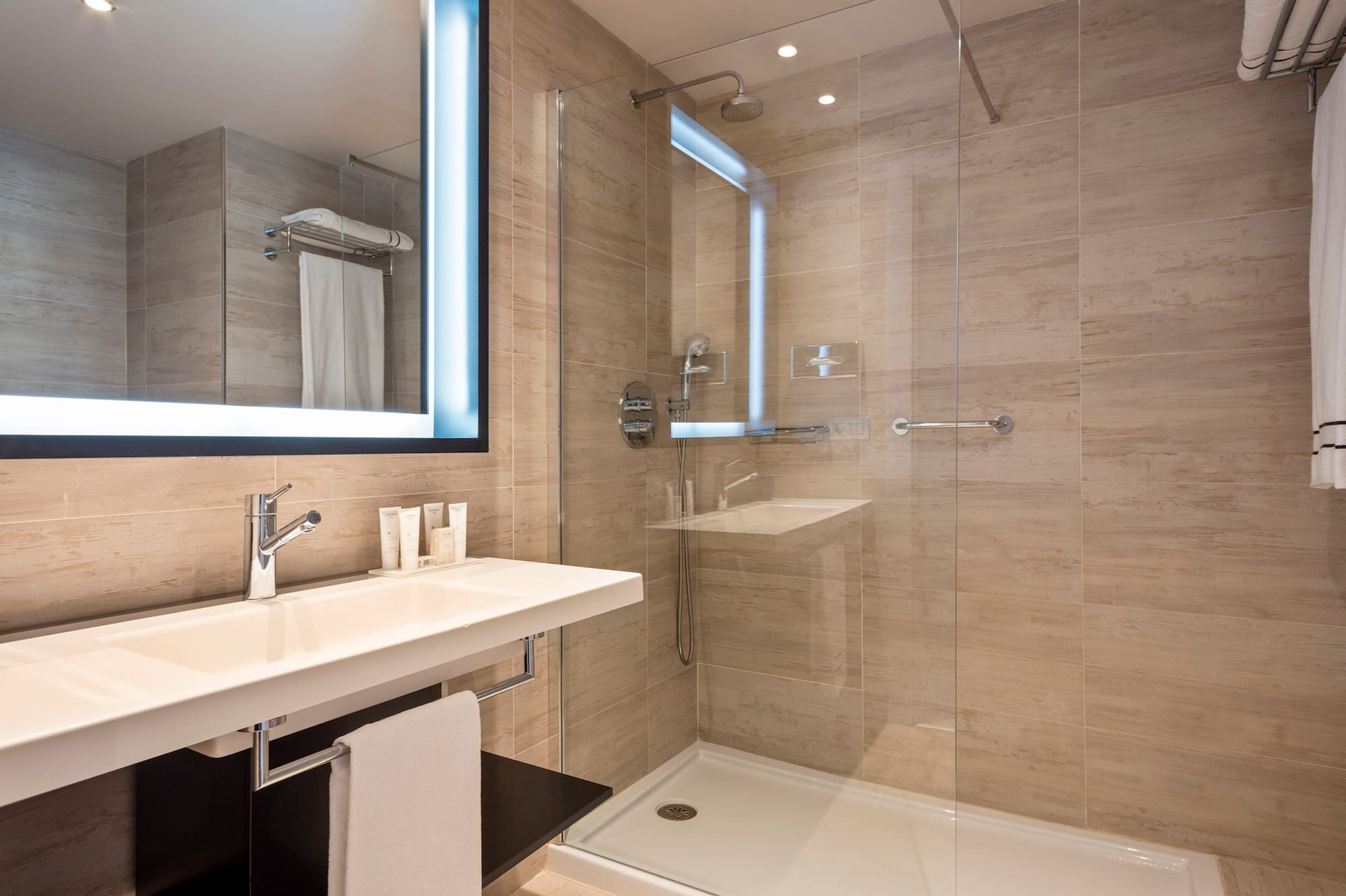 a bathroom with a glass shower and a sink