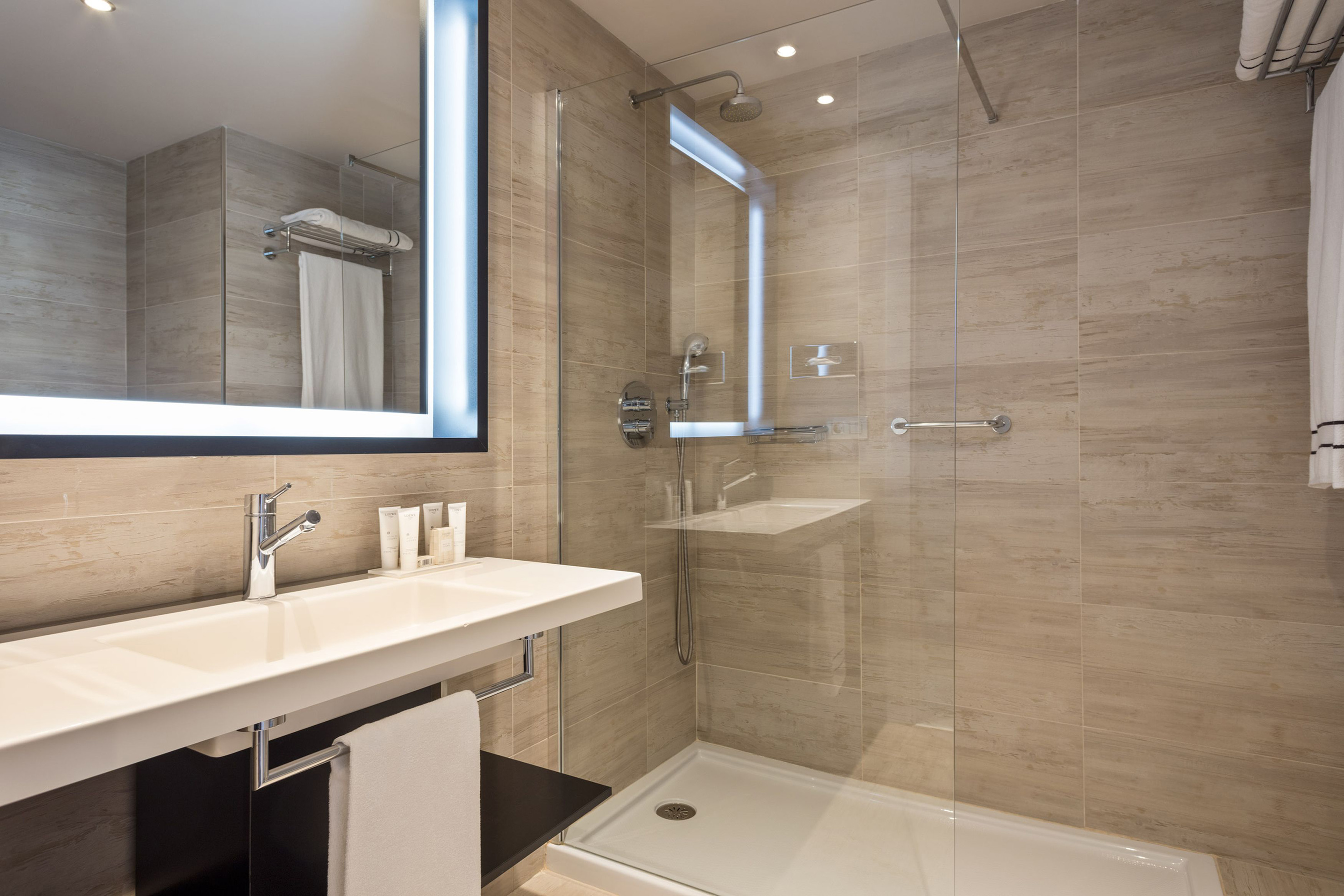 a bathroom with a glass shower and a sink