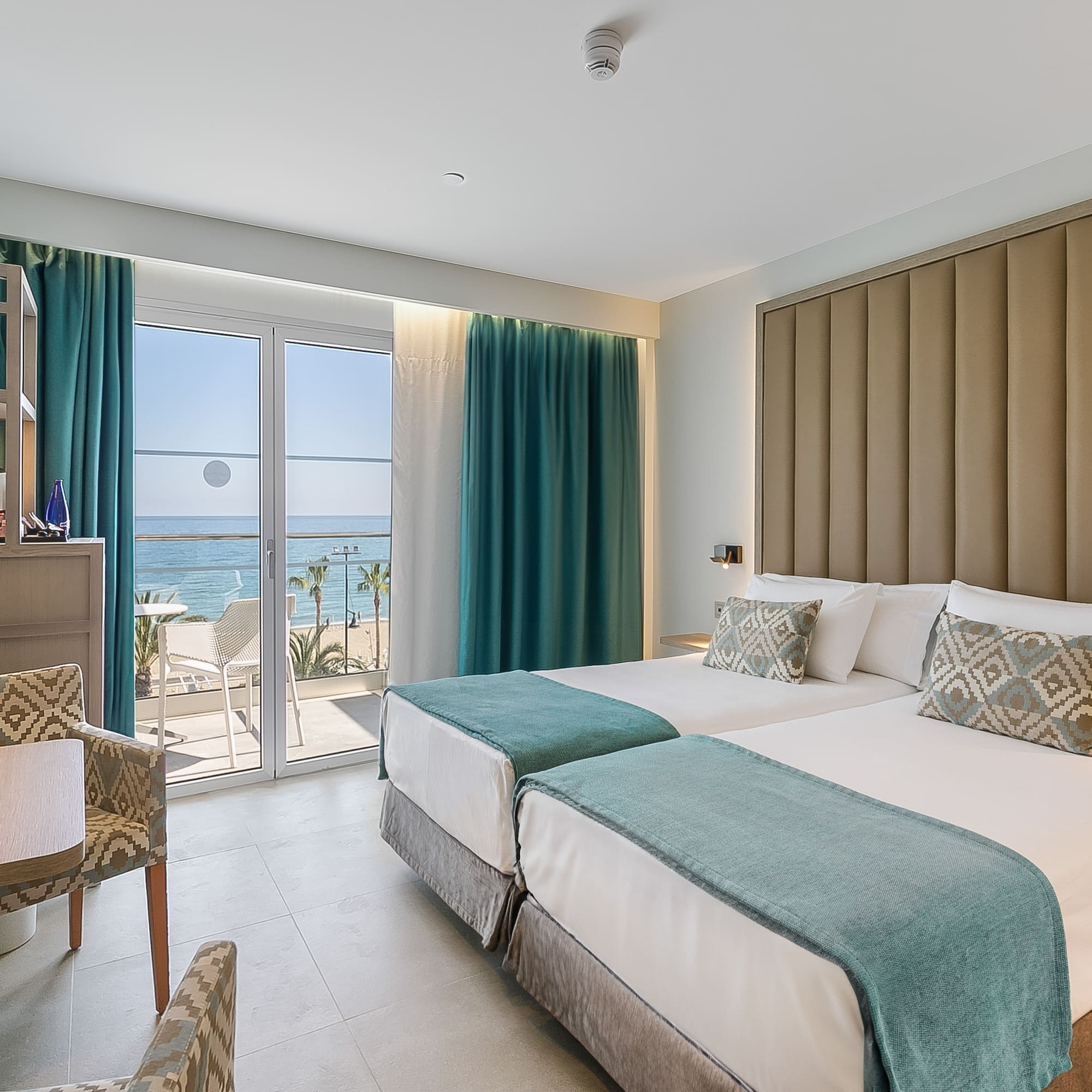 a room with two beds and a glass door