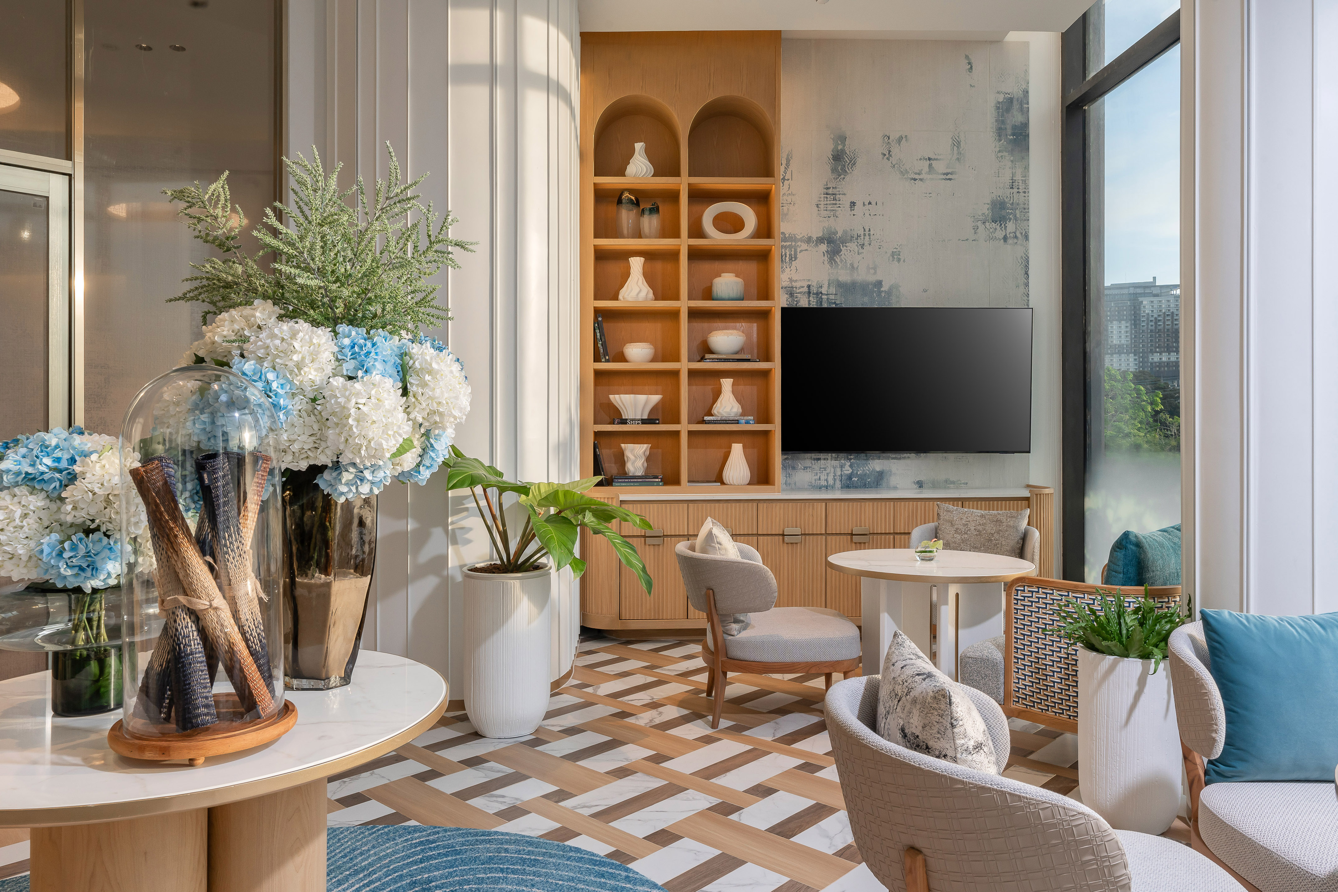 Modern lounge with blue hydrangeas, wooden shelving, and contemporary seating. - Hãy để bản thân đắm mình trong thế giới xa hoa cùng tiện nghi độc quyền - Meliá Pattaya Hotel, Pattaya