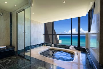a bathroom with a hot tub and a large window