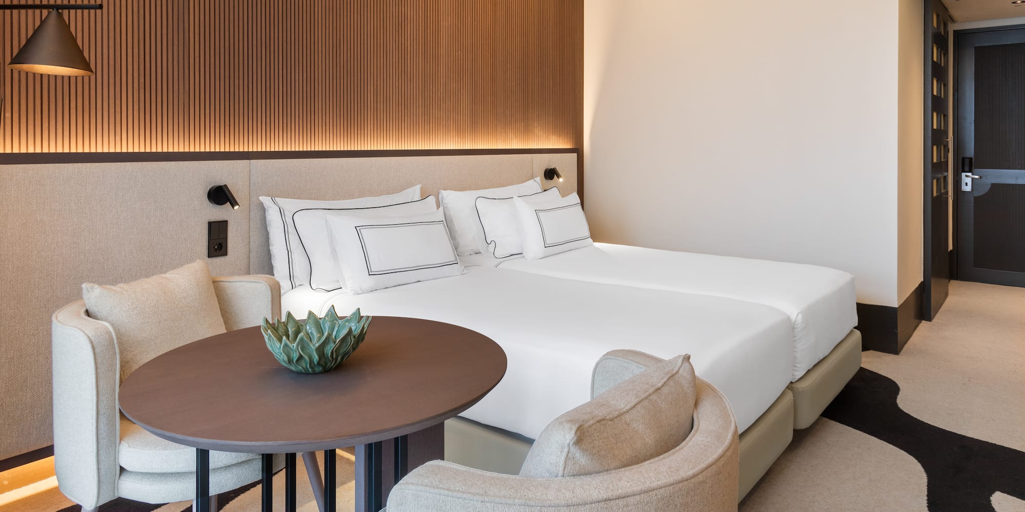 a room with a bed and chairs