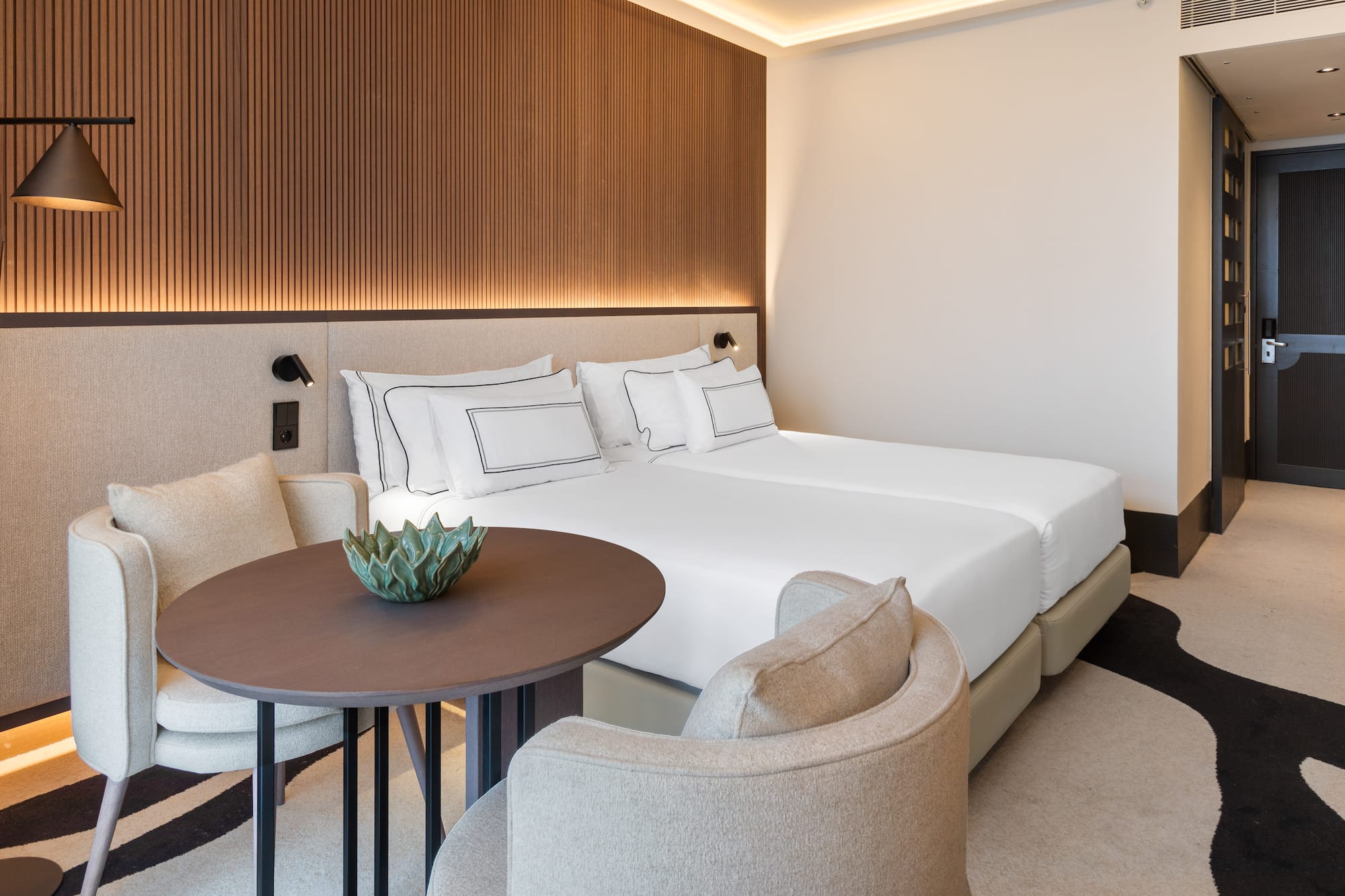 a room with a bed and chairs